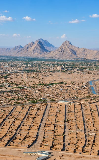 Aerial view of Kandahar's dense low-rise desert city with rugged mountains behind