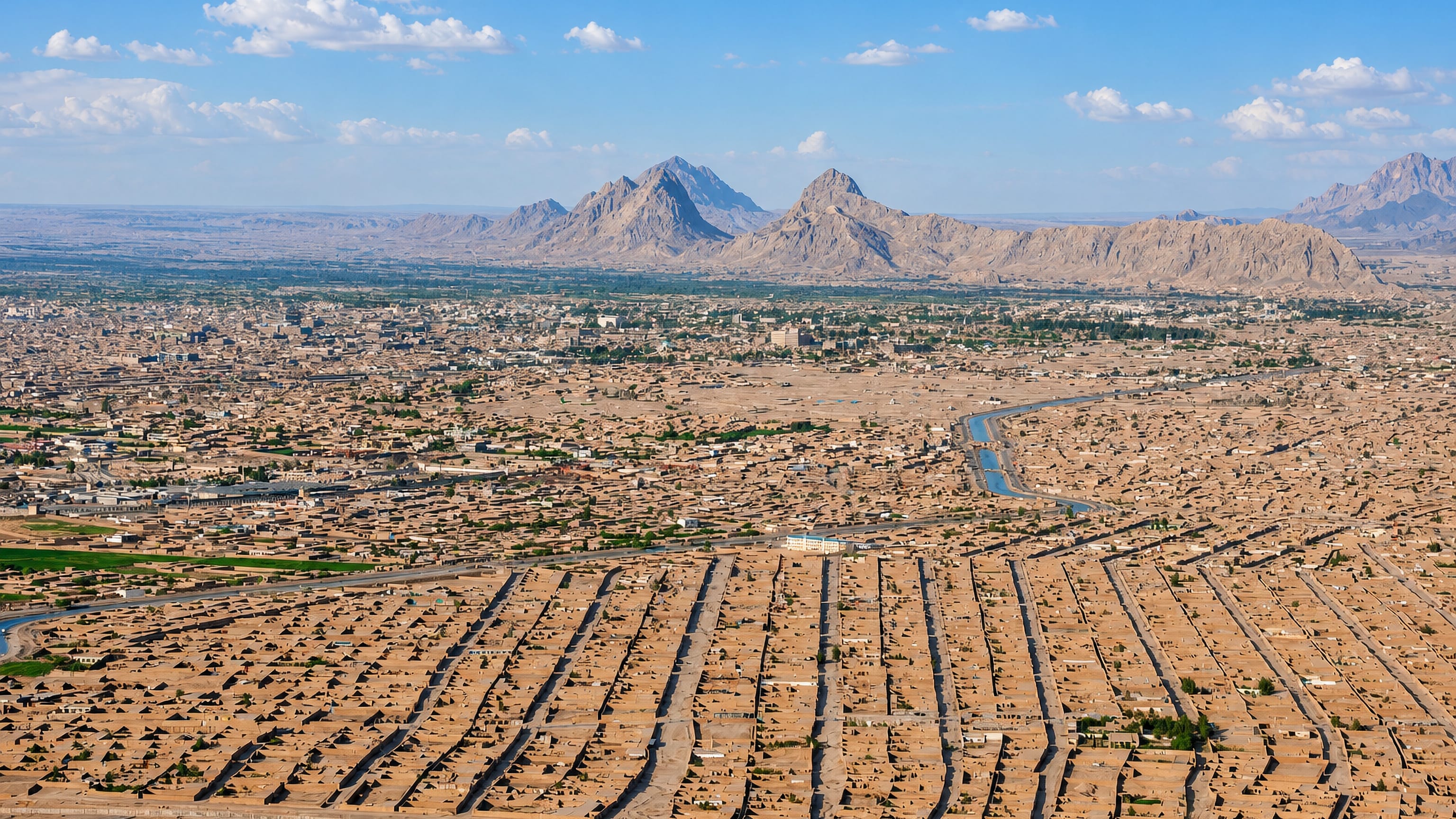 Aerial view of Kandahar's dense low-rise desert city with rugged mountains behind