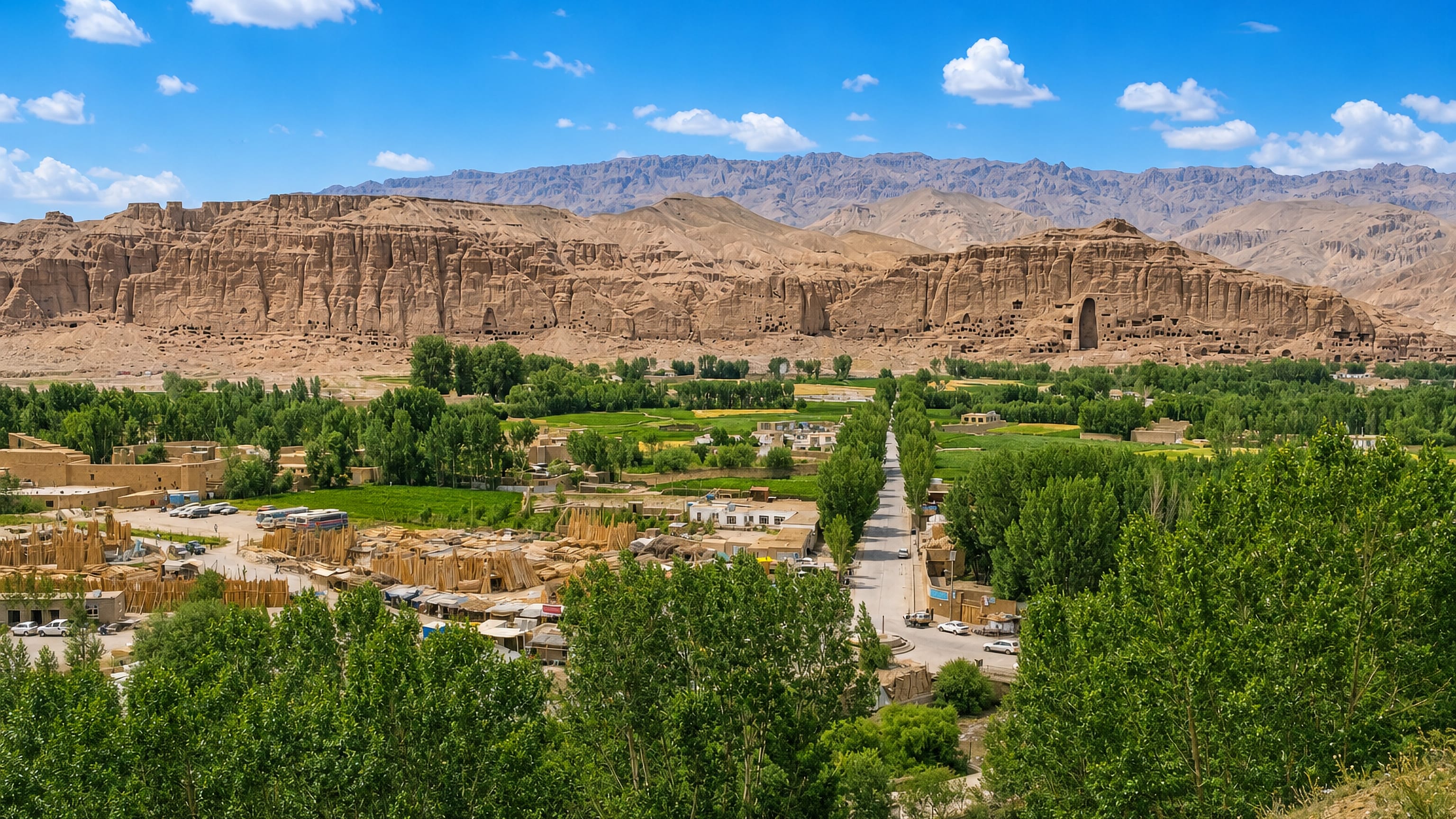 The Bamyan valley in Afghanistan, its bazaar and poplar groves below the sandstone cliff with the empty Buddha niches.