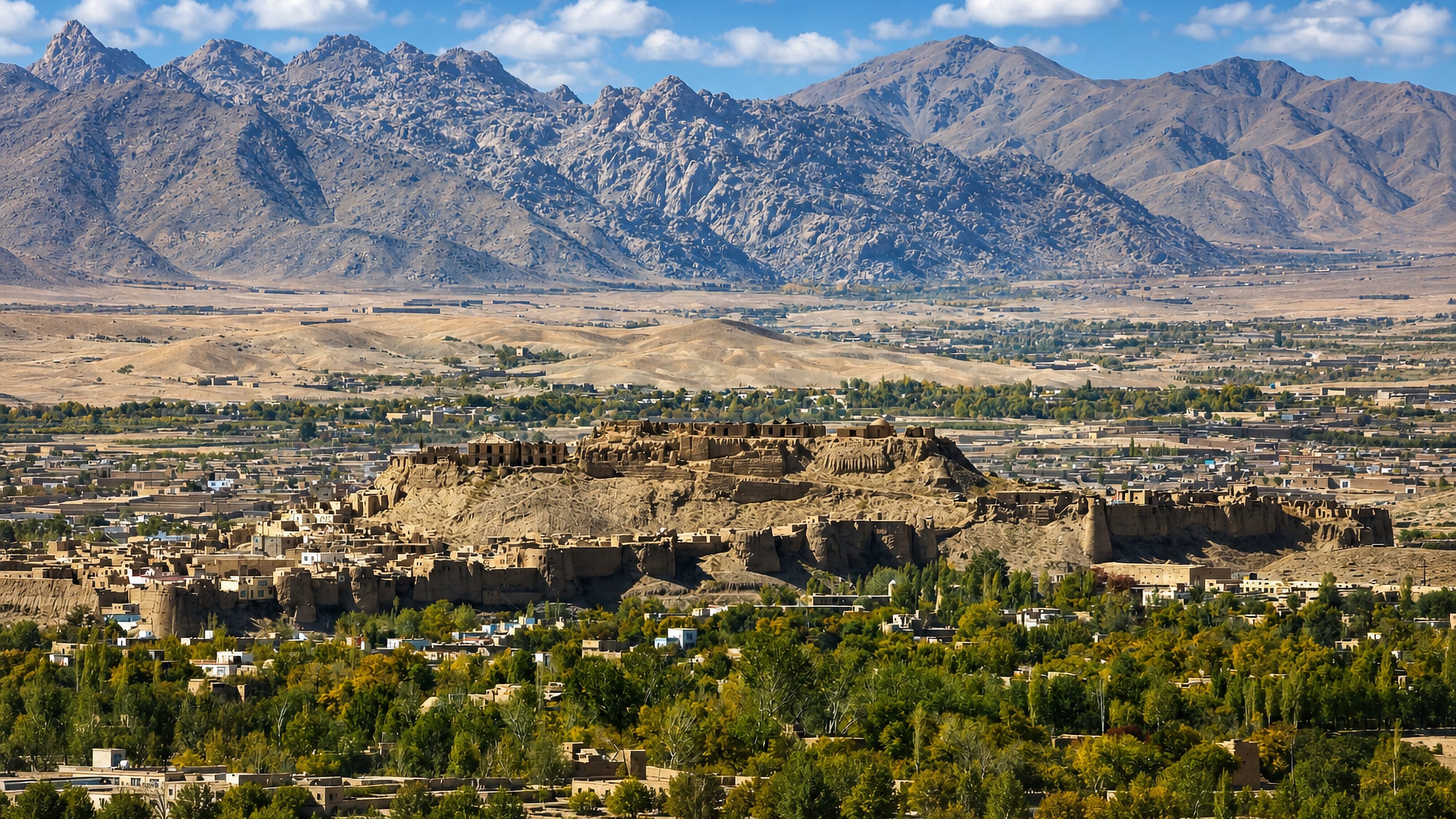 The hilltop citadel of Ghazni, Afghanistan, above mud-brick homes and poplar groves, with arid mountains beyond.