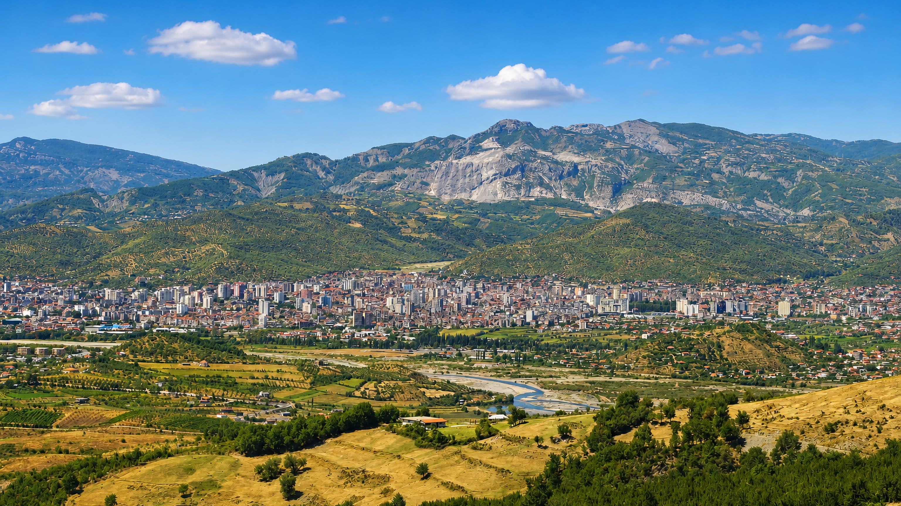 Elbasan spread across the Shkumbin valley below wooded mountains and limestone cliffs in central Albania.