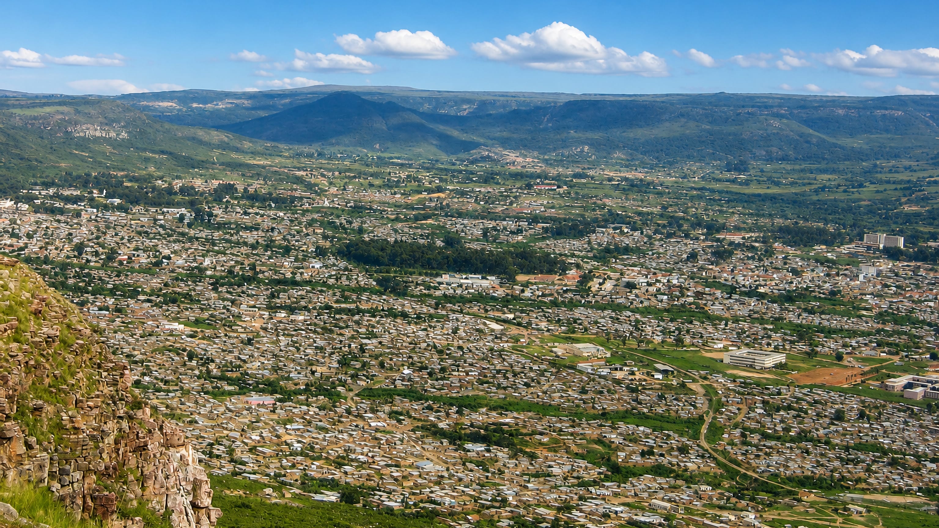 Lubango, Angola, spreading across its valley below the escarpment, viewed from a rocky ridge