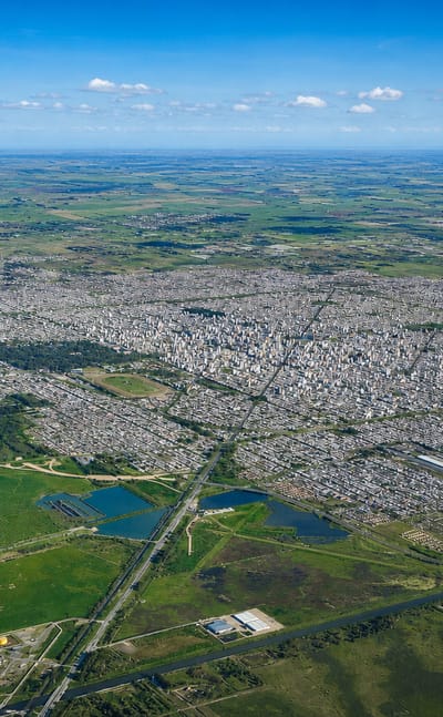 High aerial of La Plata's vast planned city grid spreading across the green pampas to the horizon