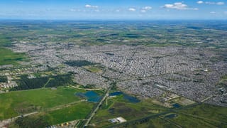 High aerial of La Plata's vast planned city grid spreading across the green pampas to the horizon