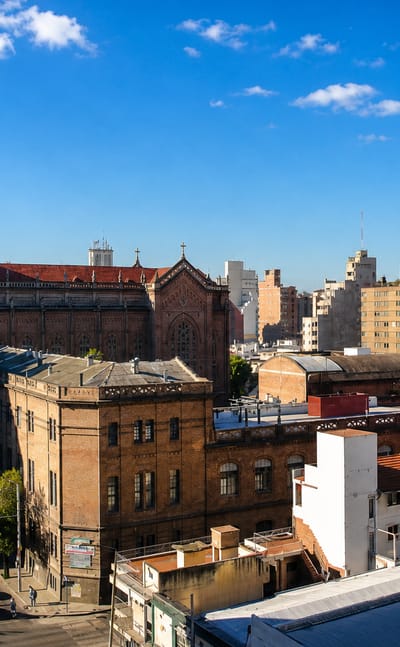Cordoba townscape with a large neo-Gothic brick church and clustered rooftops under a blue sky