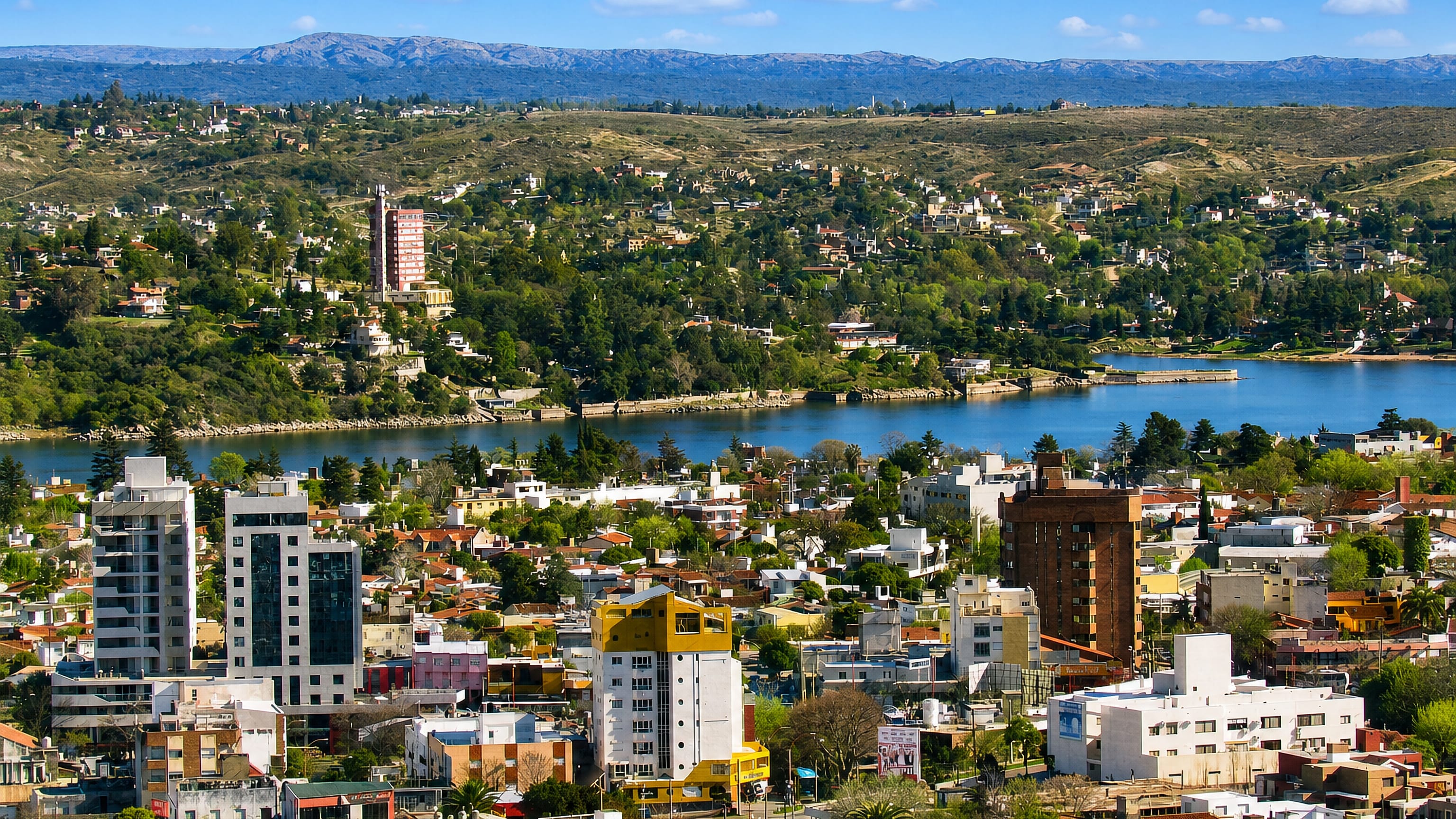 Villa Carlos Paz, Argentina, spread around Lago San Roque with the Córdoba sierras rising behind.