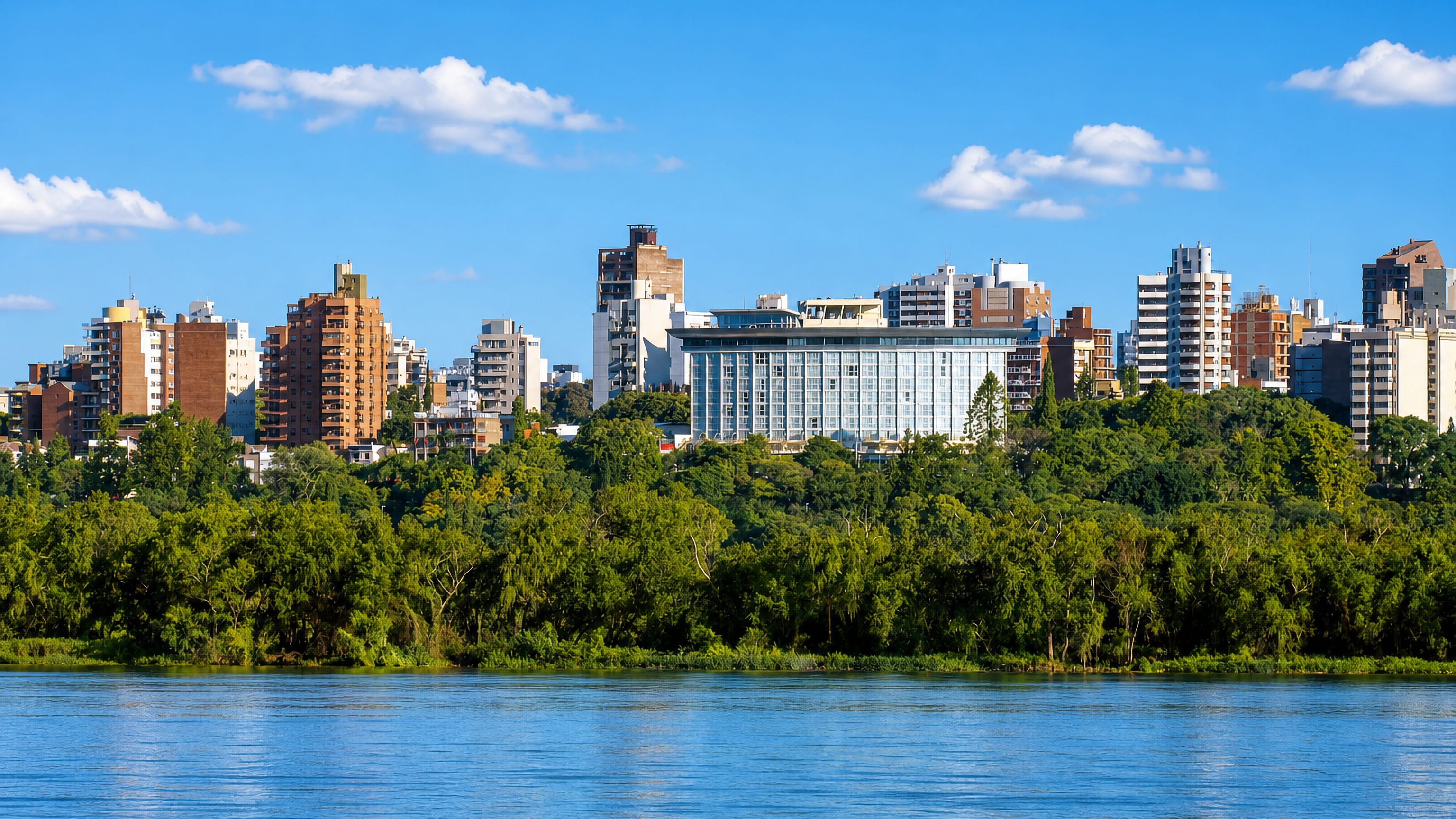 Parana, Argentina, seen across the Parana River, with riverside woods below mid-rise apartment towers.