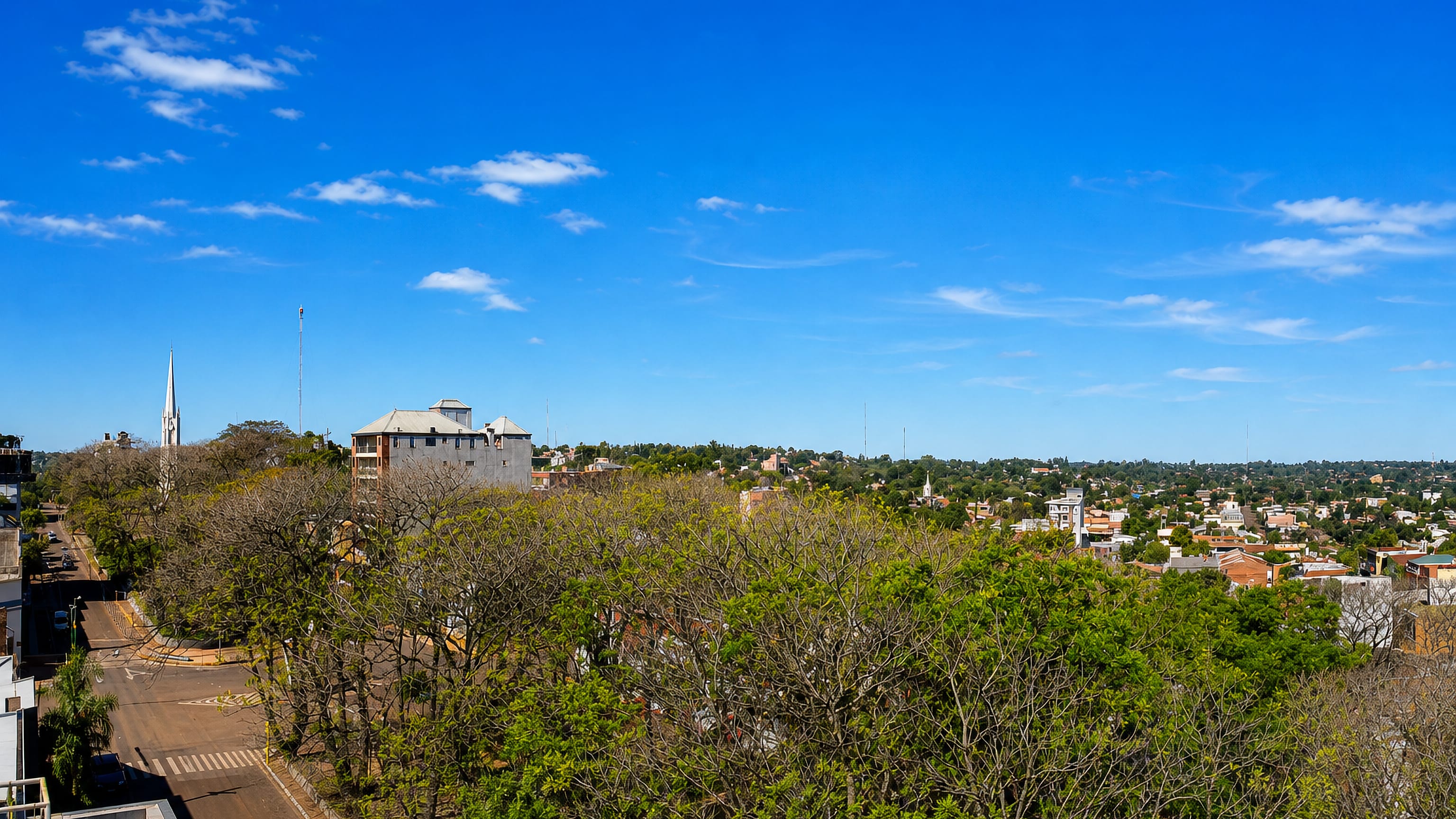 Rooftops, a church spire and leafy streets of Oberá, Misiones, spreading across the subtropical horizon.