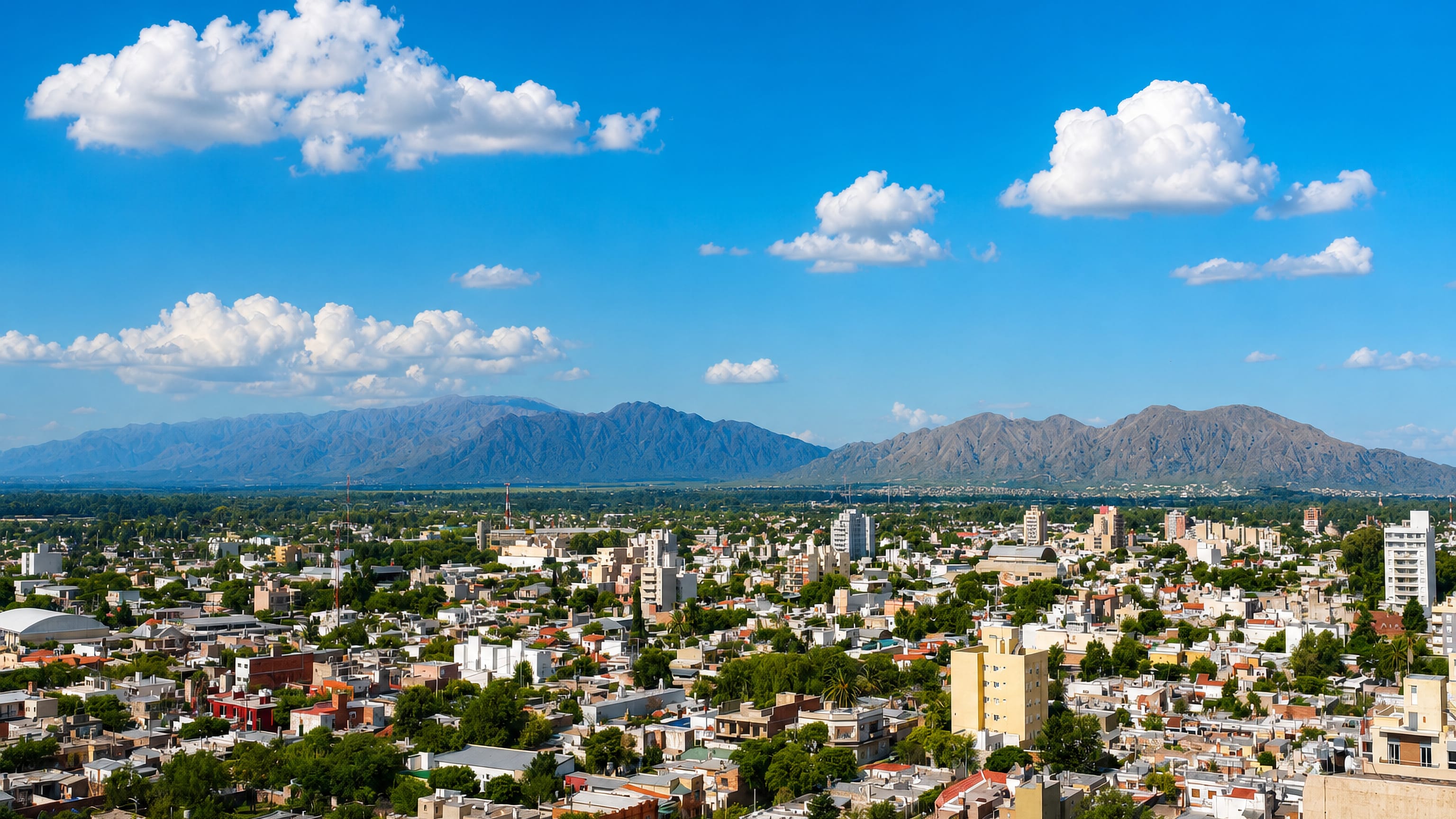 Low-rise rooftops of San Luis, Argentina, spreading toward the sierras under a bright sky
