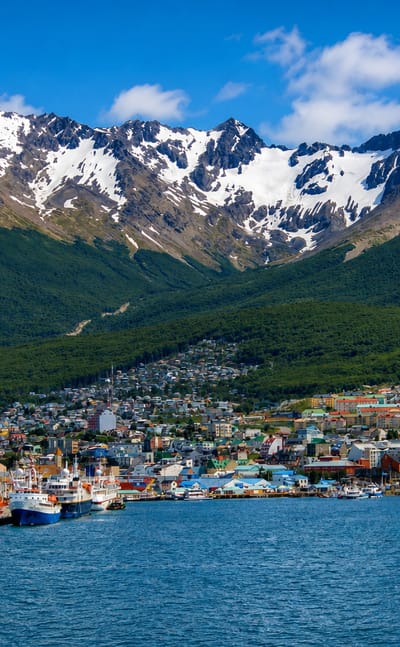 Ushuaia's colourful waterfront and harbour below the snow-capped Martial mountains on the Beagle Channel, Argentina