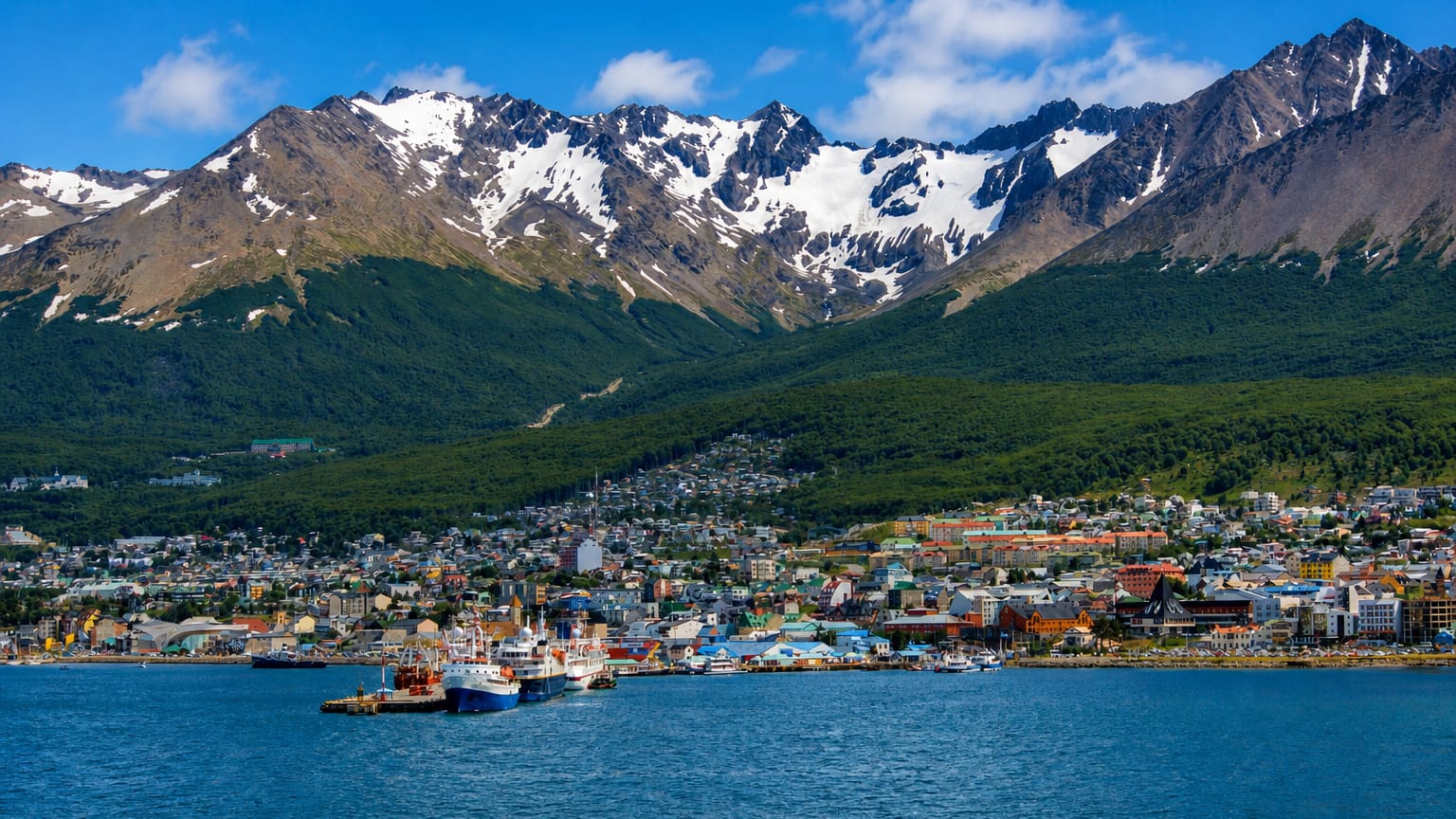Ushuaia's colourful waterfront and harbour below the snow-capped Martial mountains on the Beagle Channel, Argentina