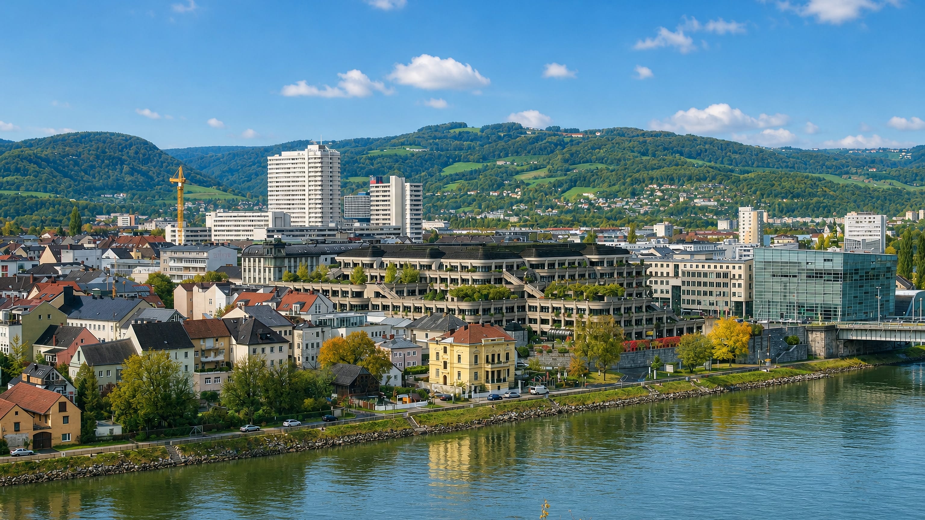 Urfahr on the north bank of the Danube in Linz, with wooded hills and the glass Ars Electronica Center