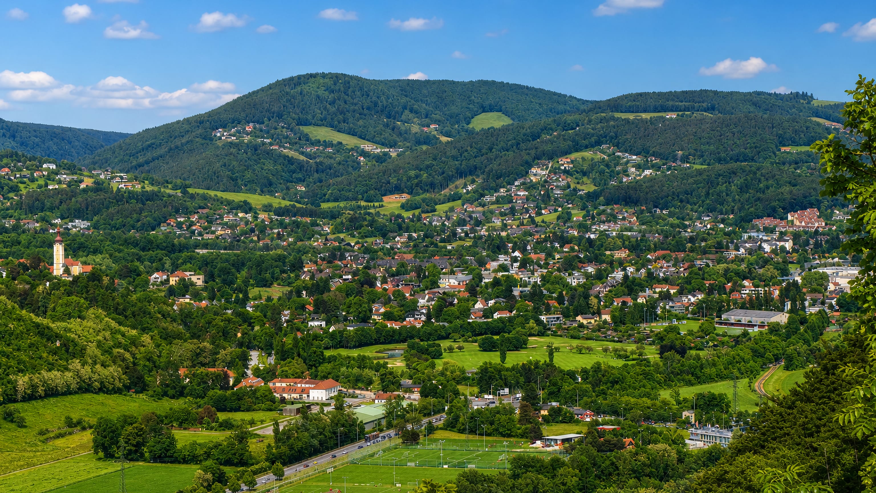 Wooded hills, a church tower and scattered houses above the green valley of Andritz on the northern edge of Graz.