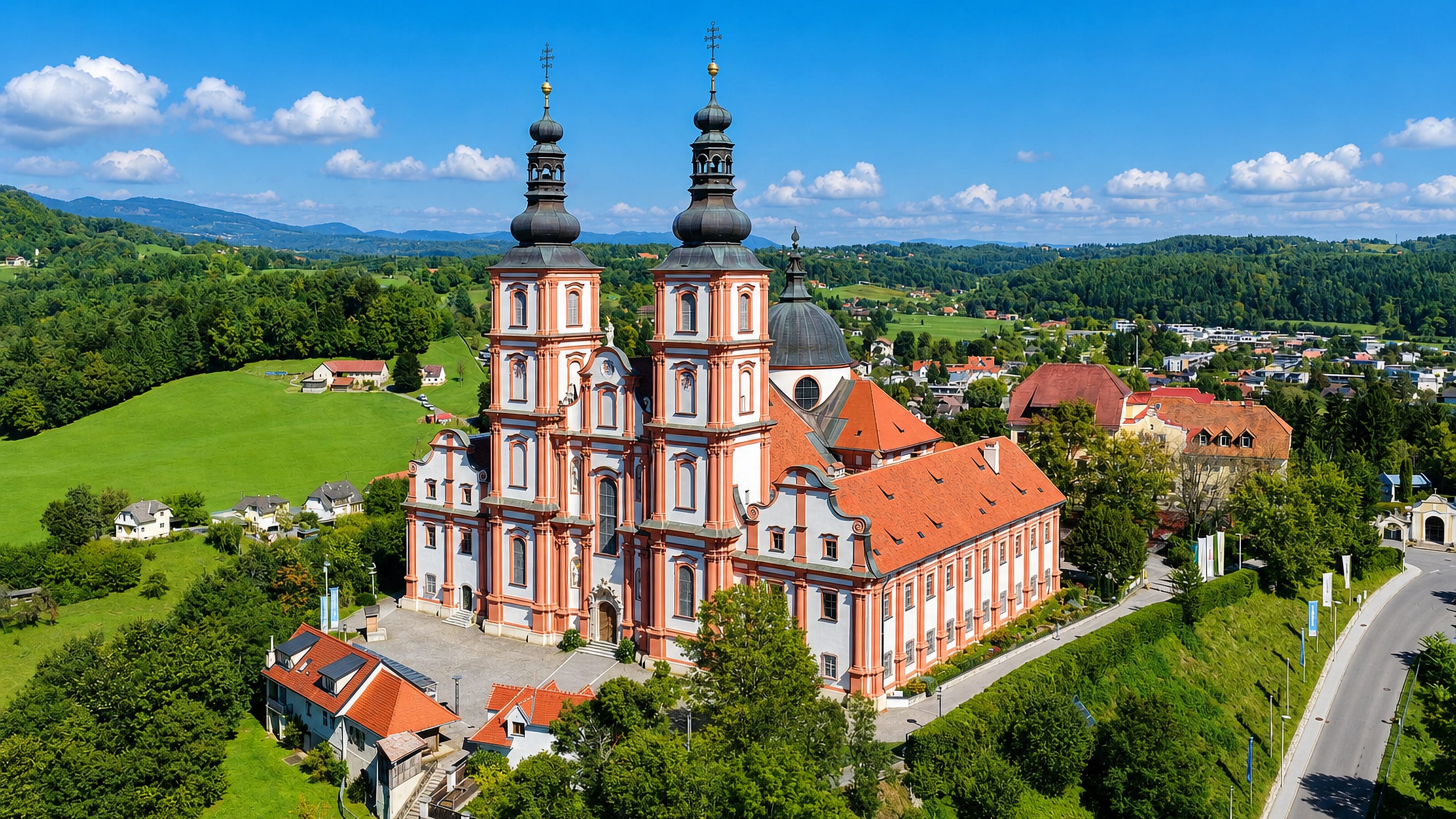 Twin-towered baroque Basilica Mariatrost on its wooded hill above Graz, with Styrian countryside beyond