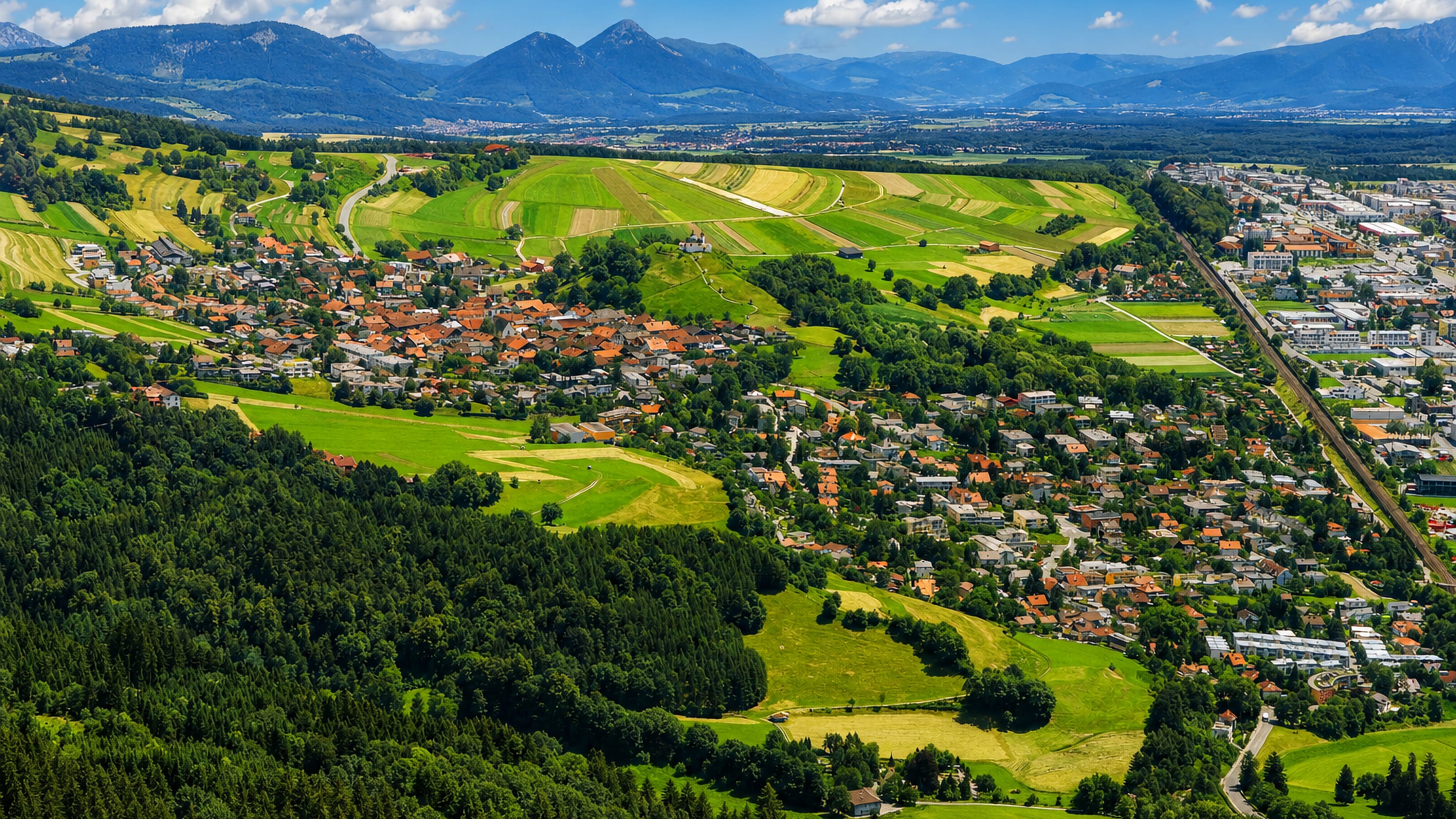 Aerial view of Arzl's houses and green terraces on the slope above the Inn valley near Innsbruck.