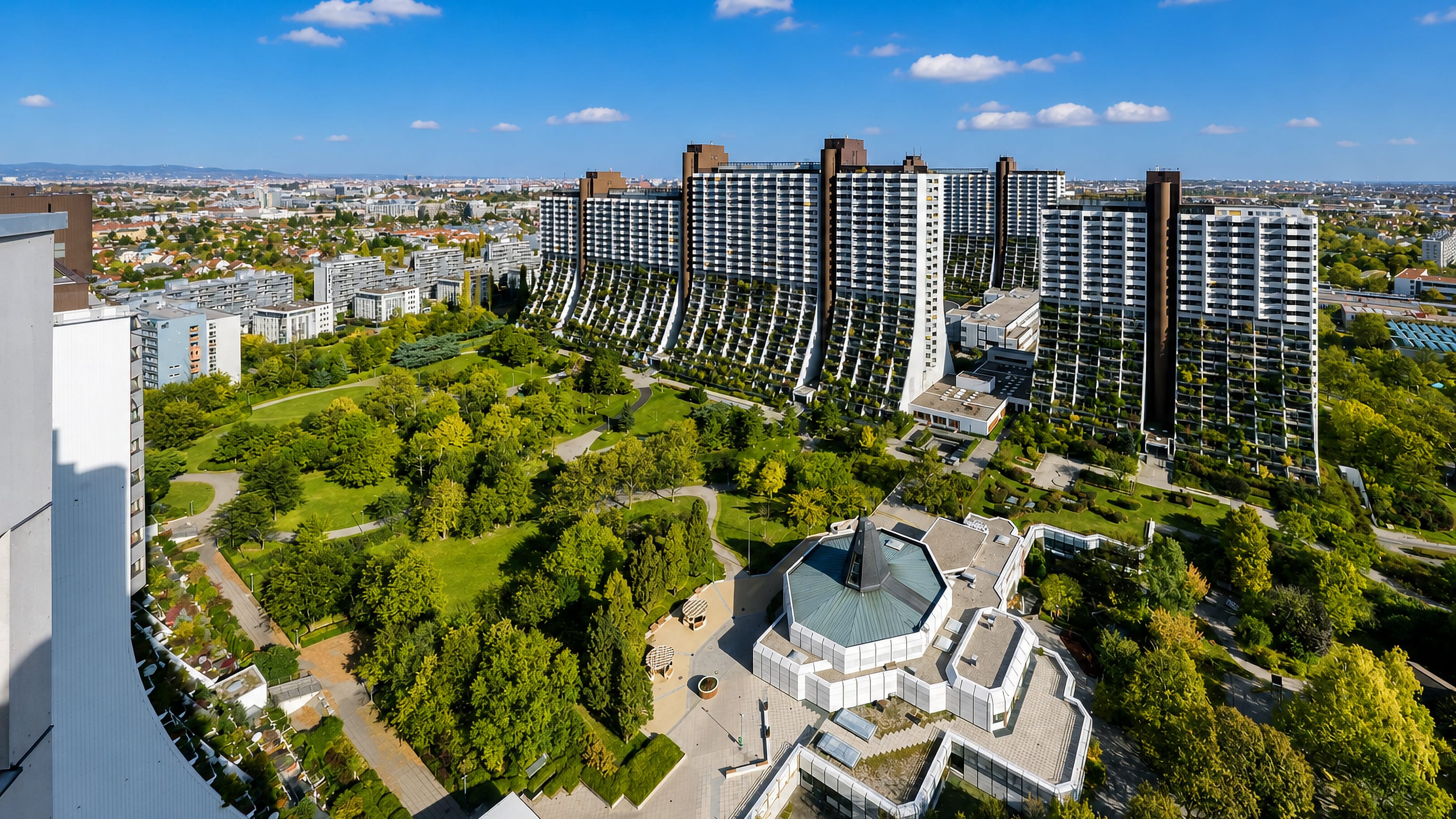 The terraced high-rise blocks and green parkland of Alterlaa in southern Vienna seen from above.