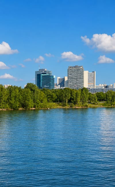 The Danube with the Donauturm tower and Donau City skyline seen from the Brigittenau riverside in Vienna.
