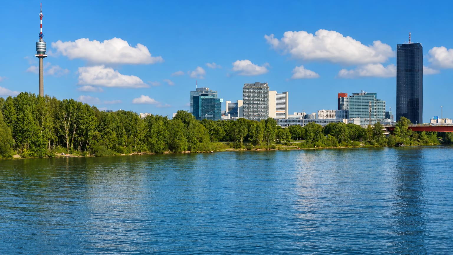 The Danube with the Donauturm tower and Donau City skyline seen from the Brigittenau riverside in Vienna.