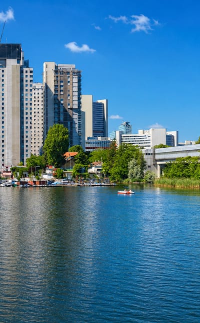 The DC Tower and Donau City high-rises rising above the Alte Donau waterfront with boats in Donaustadt, Vienna.