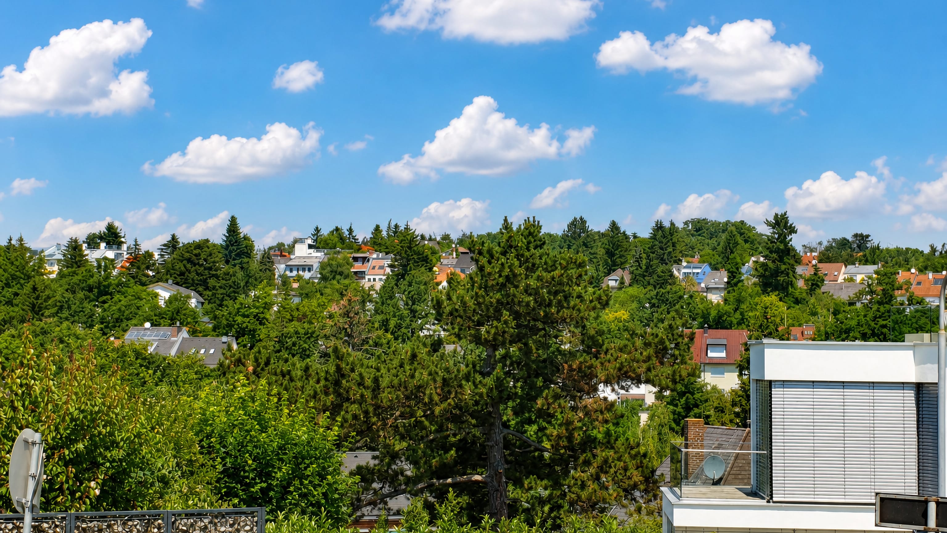 Rooftops of villas among dense trees on a wooded slope at Friedensstadt in Vienna