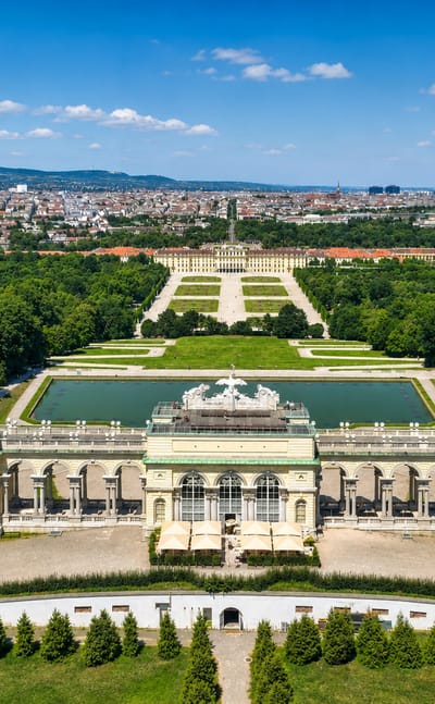 Aerial of Schoenbrunn Palace and its formal gardens in Hietzing, Vienna, with the city spread out behind