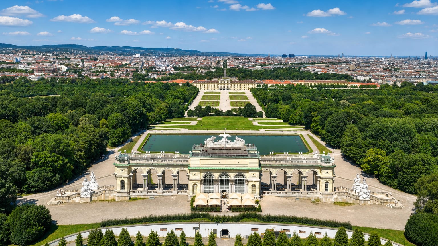 Aerial of Schoenbrunn Palace and its formal gardens in Hietzing, Vienna, with the city spread out behind