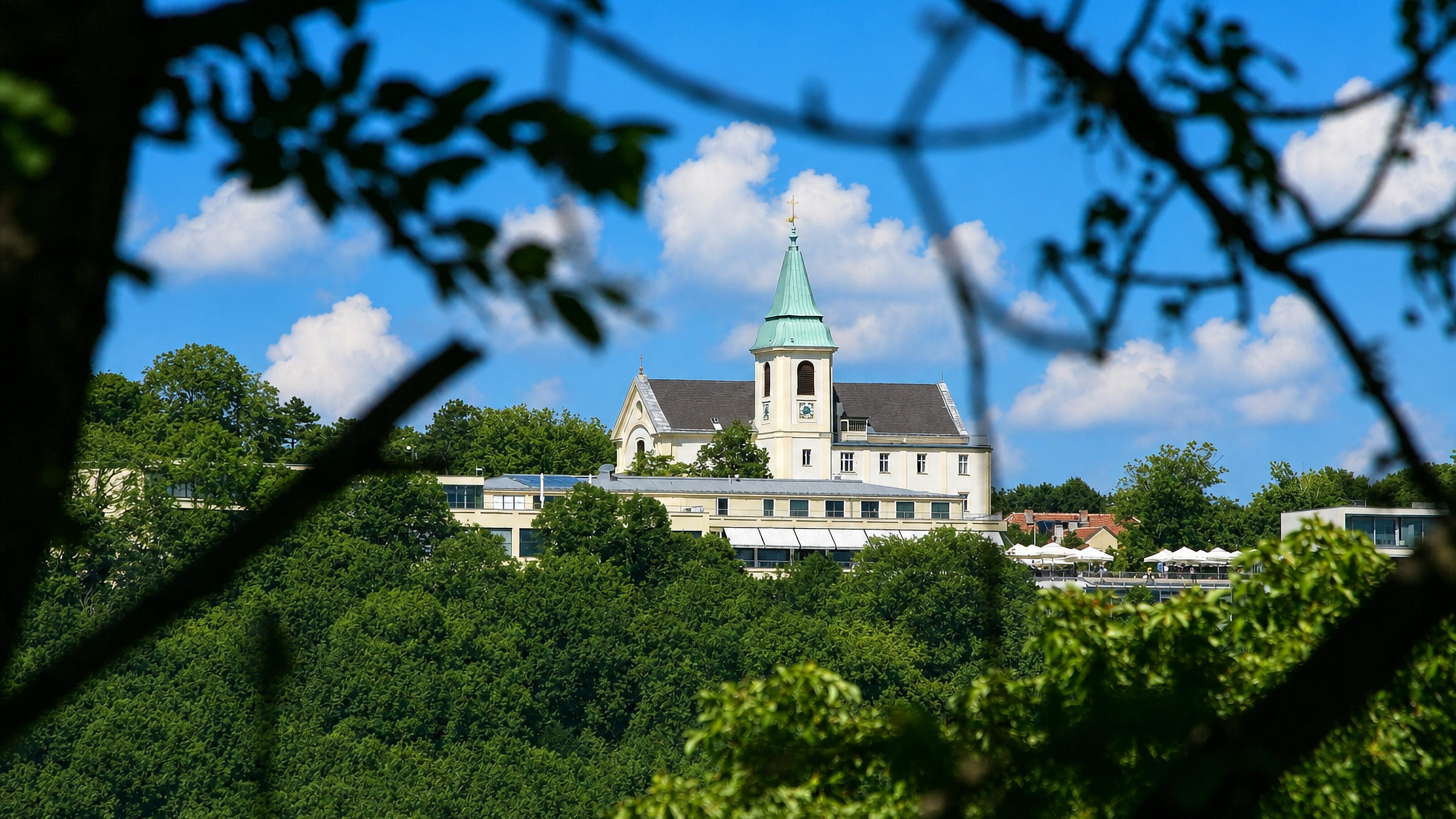The church of St Josef on the Kahlenberg at Josefsdorf, Vienna, above wooded slopes.
