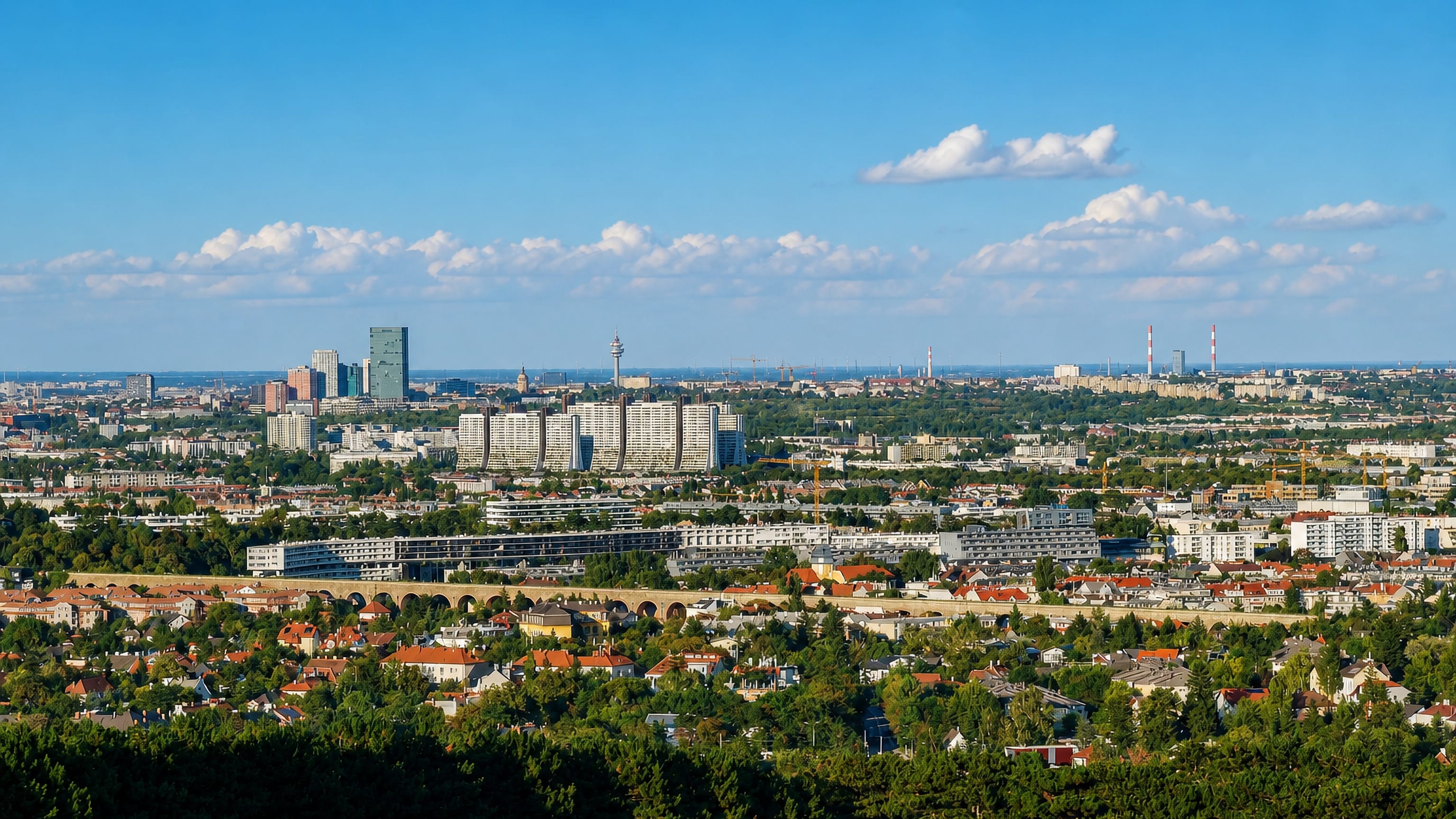 Panorama over Liesing's villa quarters and terraced housing slabs to Vienna's distant skyline and Donauturm.