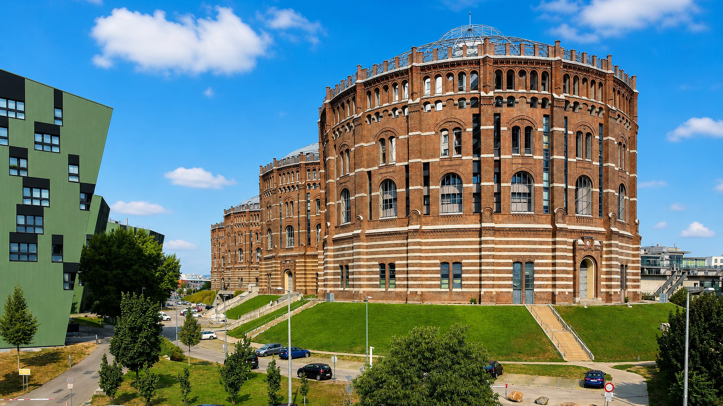 The brick Gasometer rotunda and its angular green annexe in Simmering, Vienna