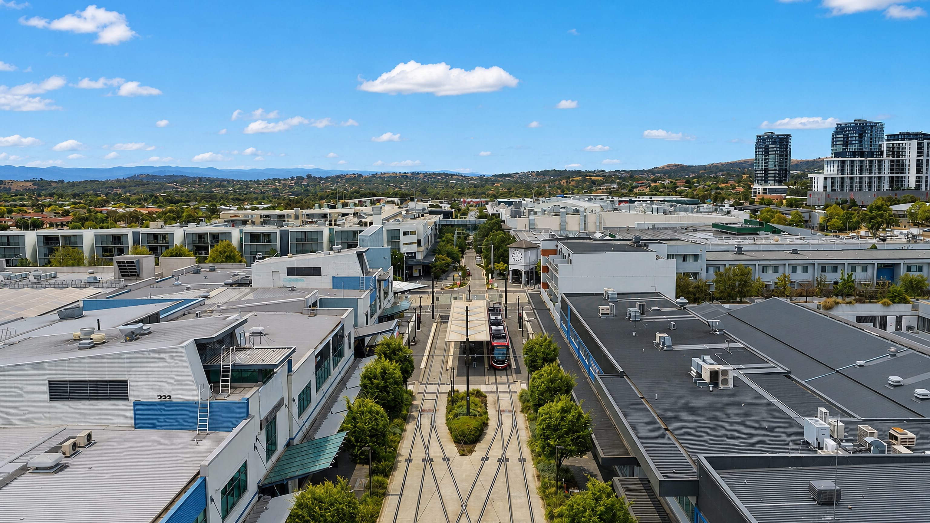 Aerial view of Gungahlin town centre, Canberra, with a light rail tram at its terminus and hills beyond.