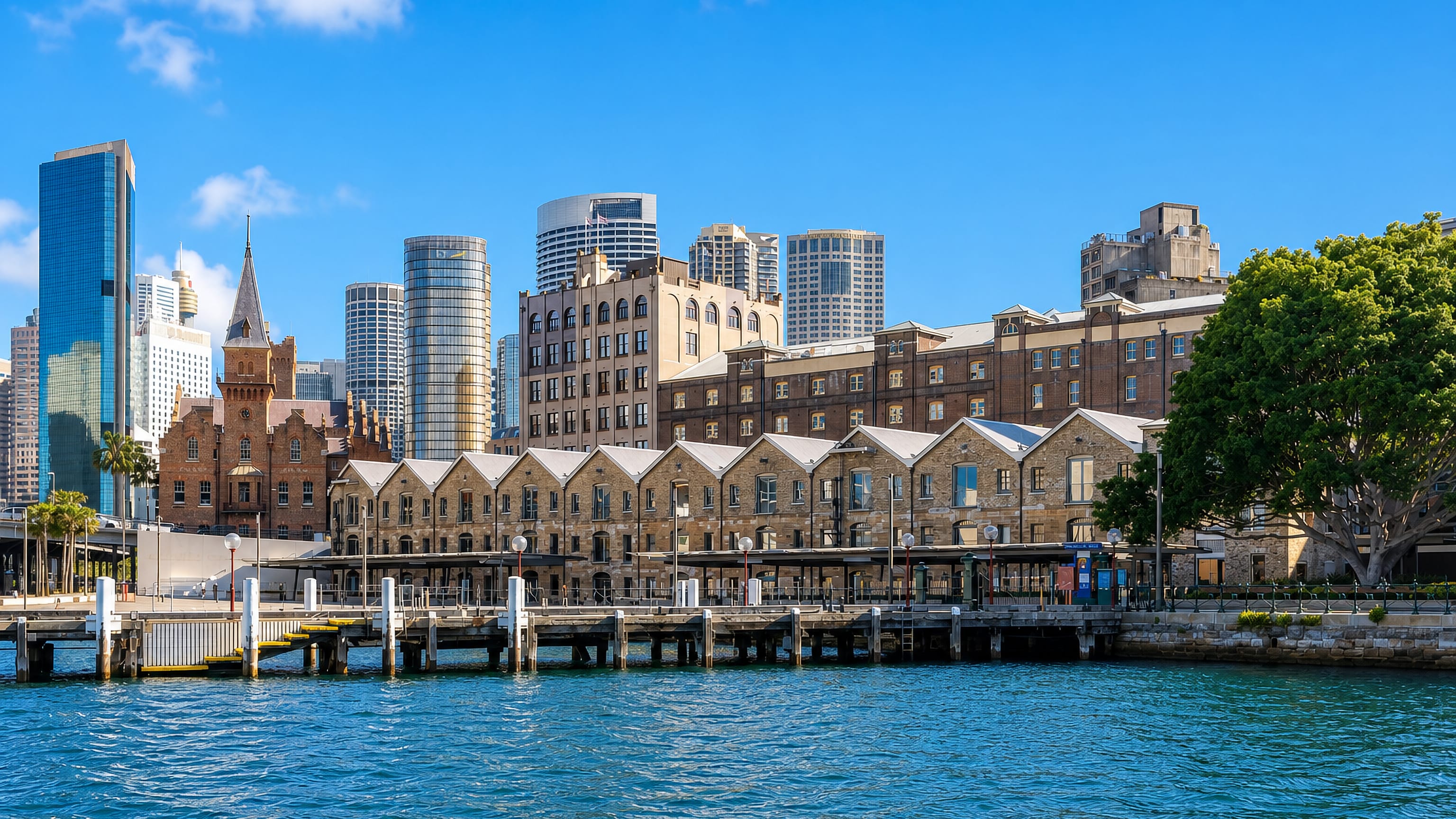 Sandstone Campbell's Storehouses at The Rocks, Sydney, fronting the harbour with CBD towers rising behind.