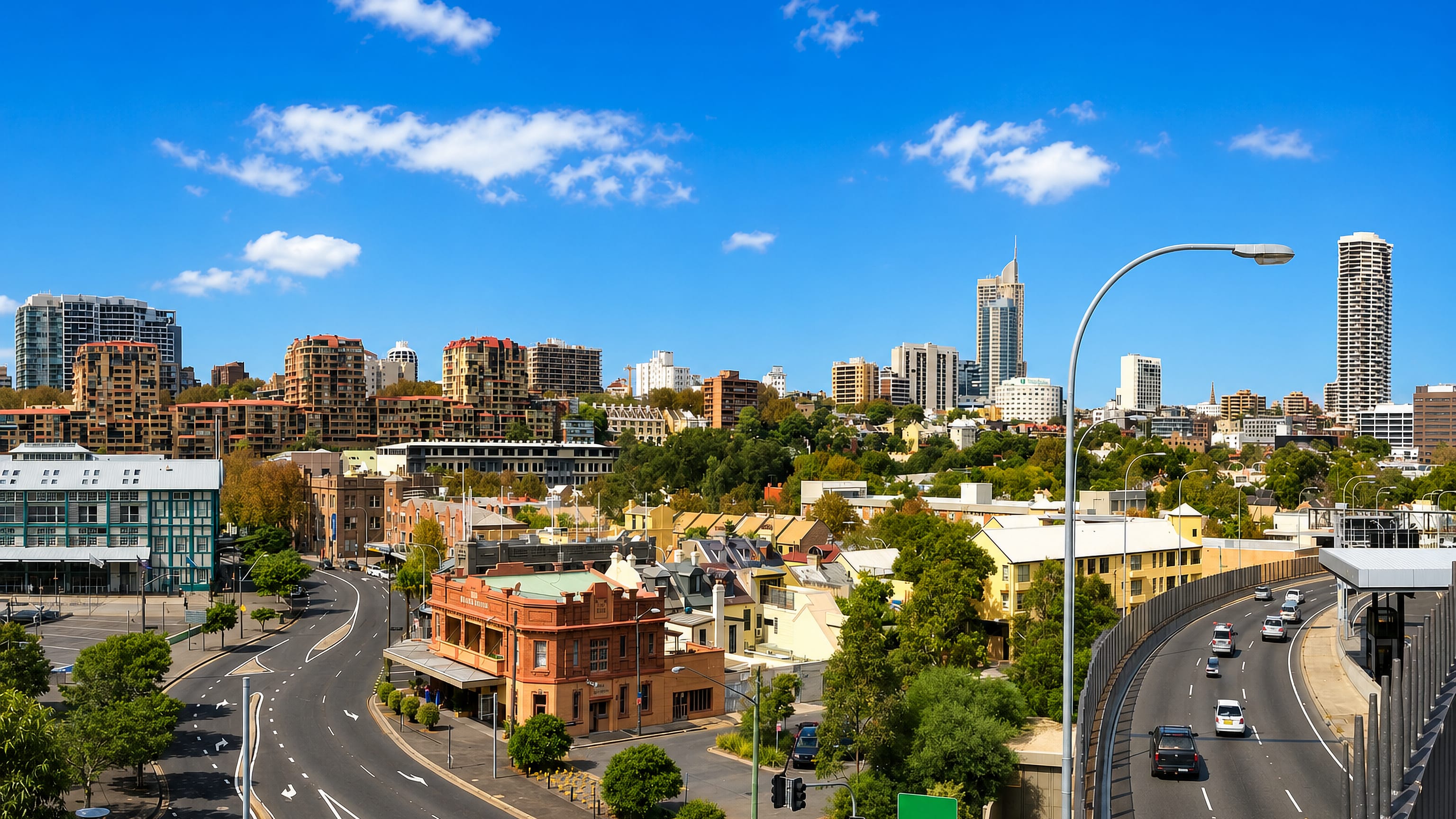 Woolloomooloo in Sydney, with a corner pub, terrace rooftops, the Eastern Distributor and city towers behind