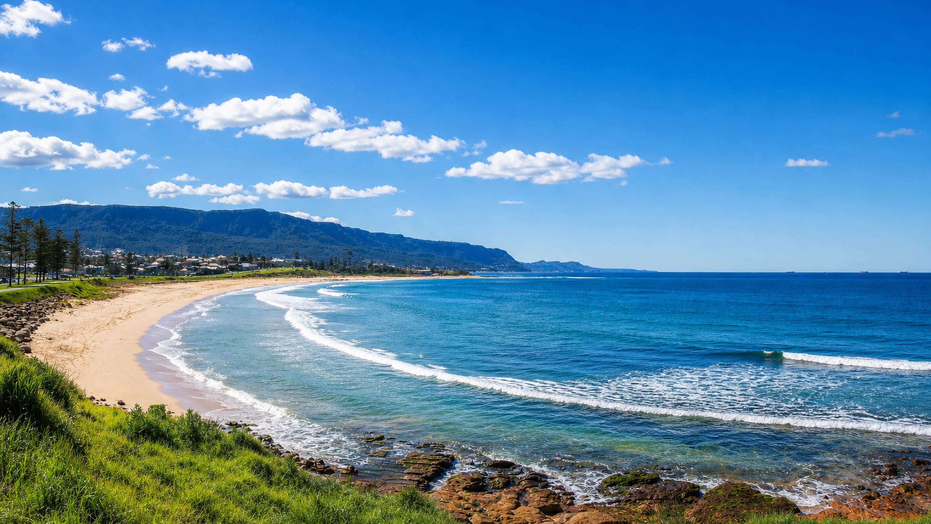 Bulli Beach curving north below the forested Illawarra escarpment on the Wollongong coast.
