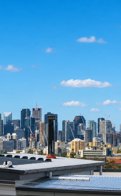 Brisbane's CBD skyline, including its tallest towers, seen across suburban rooftops from Toowong.