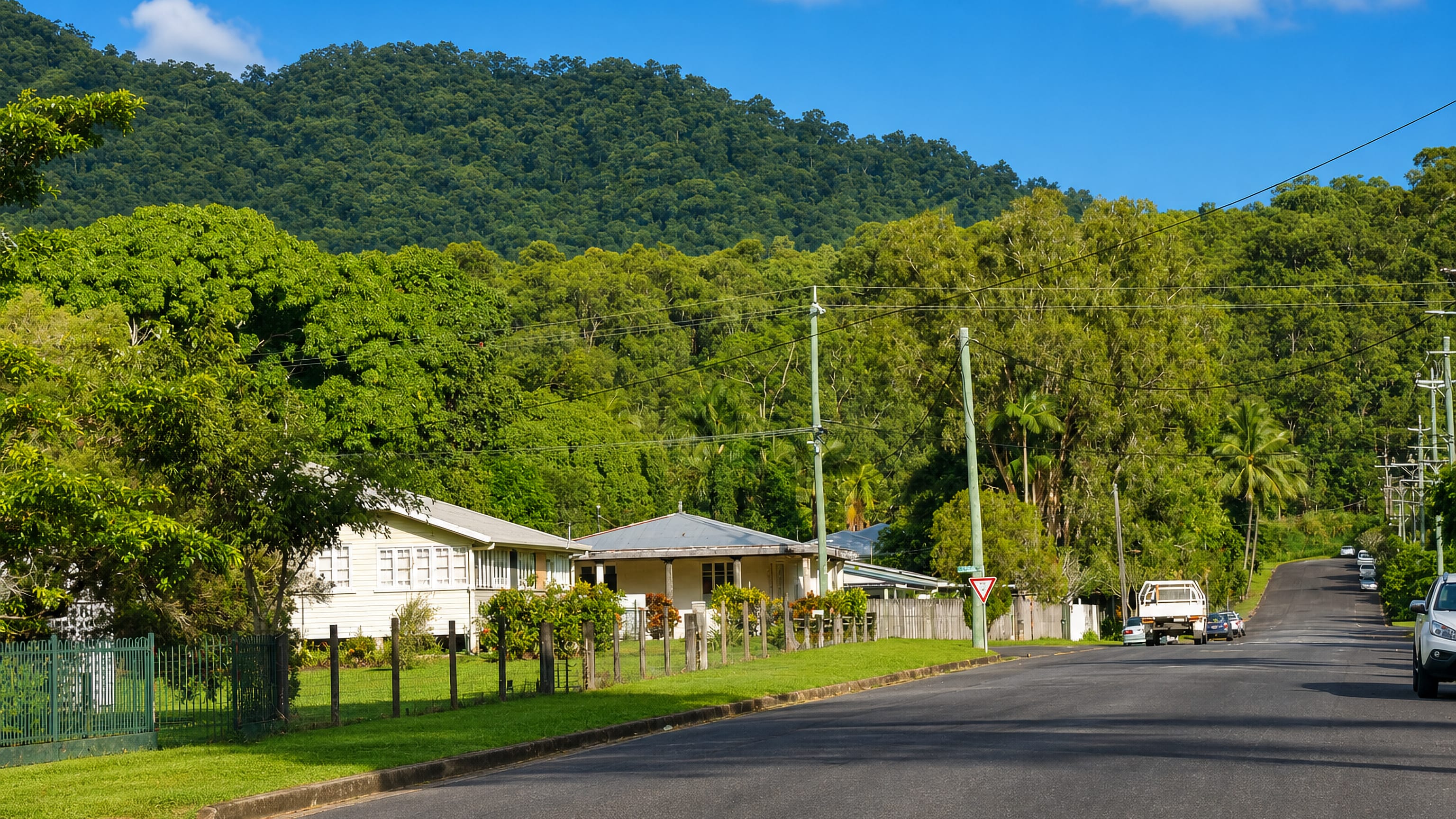Queenslander homes on a suburban street in Manoora, Cairns, below the forested slopes of the coastal range.