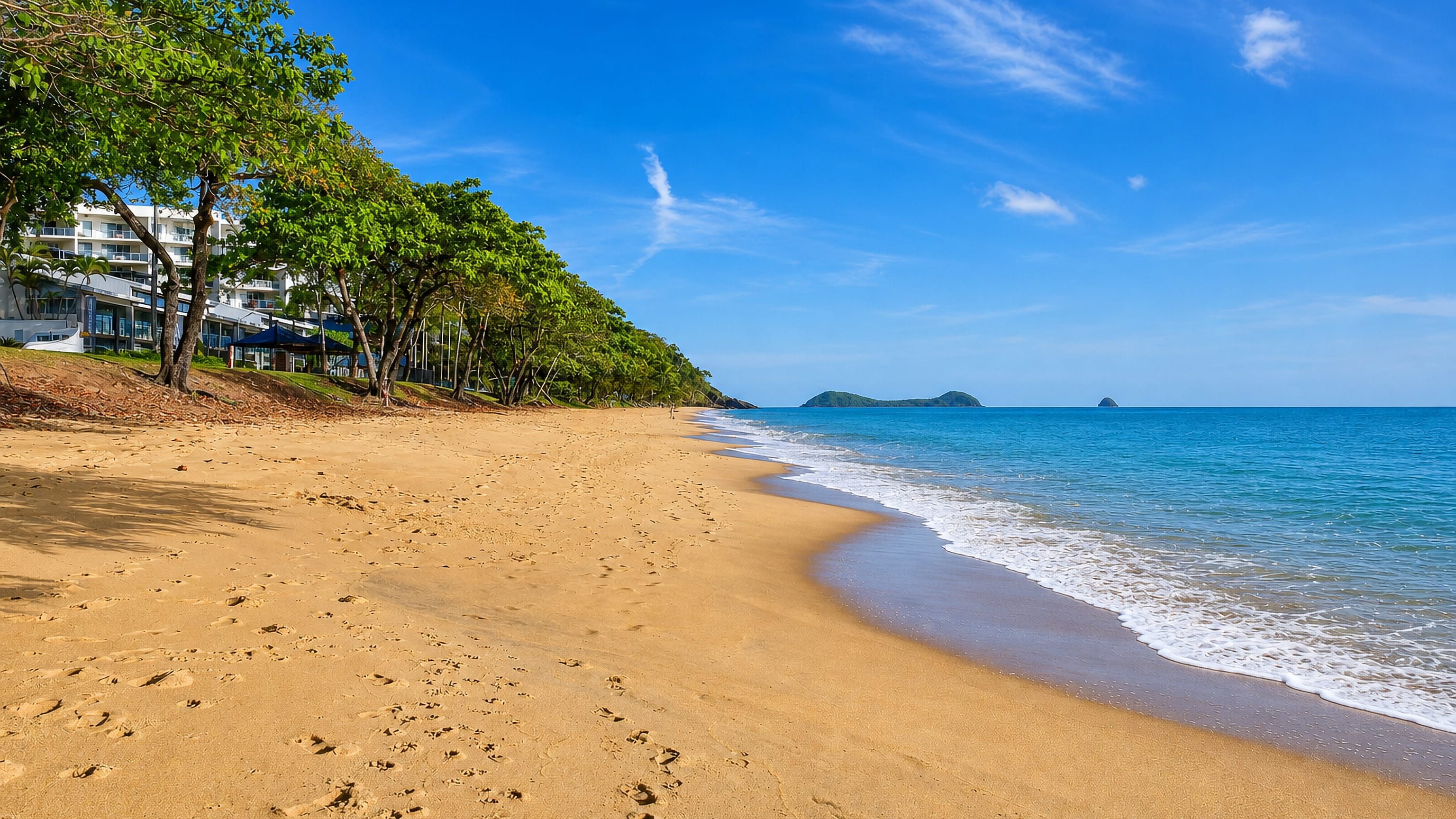 Golden sand, turquoise water and beachfront apartments at Trinity Beach north of Cairns.