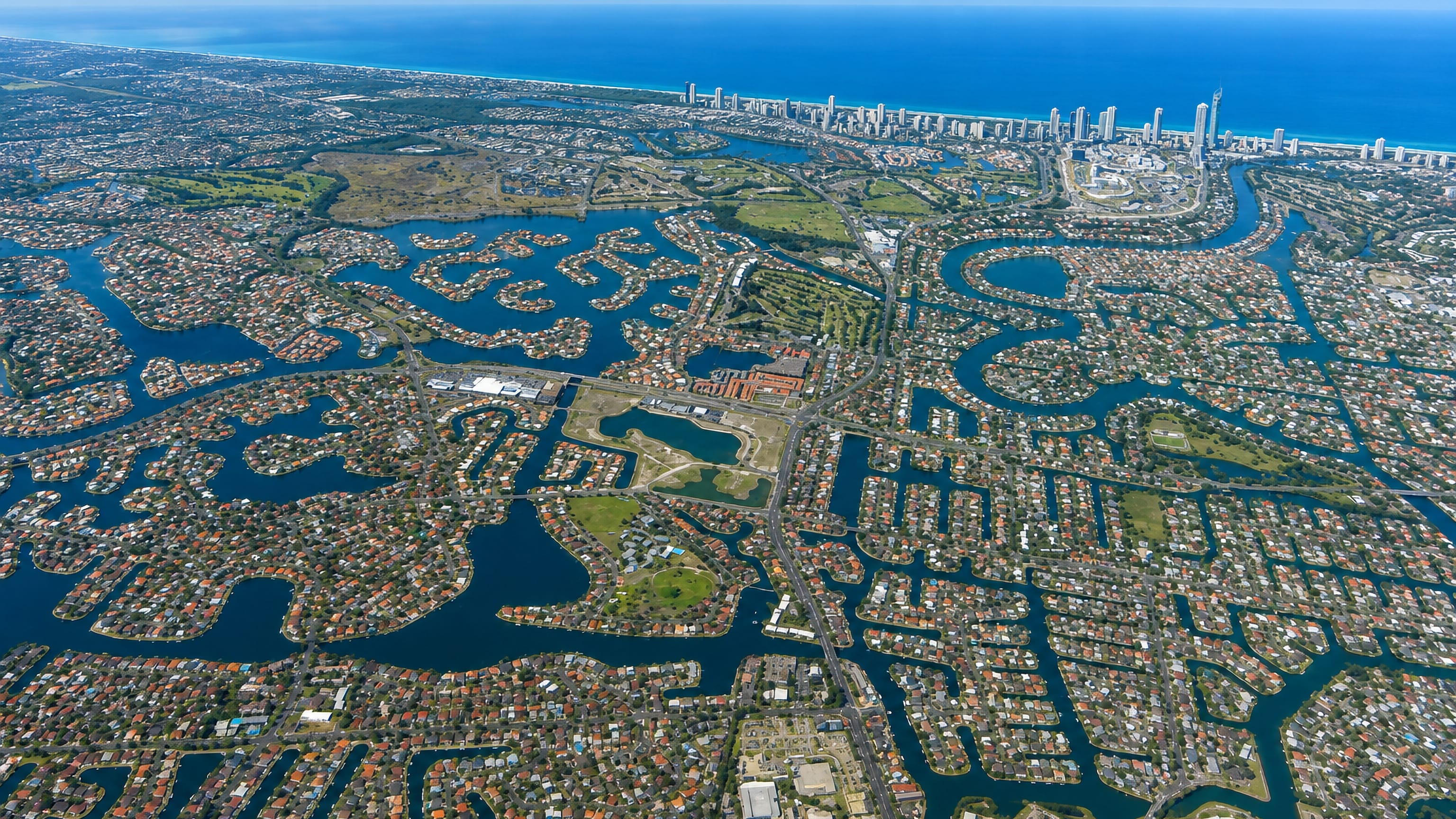 Aerial view over Broadbeach Waters canal estates on the Gold Coast, with Surfers Paradise towers and the Pacific beyond
