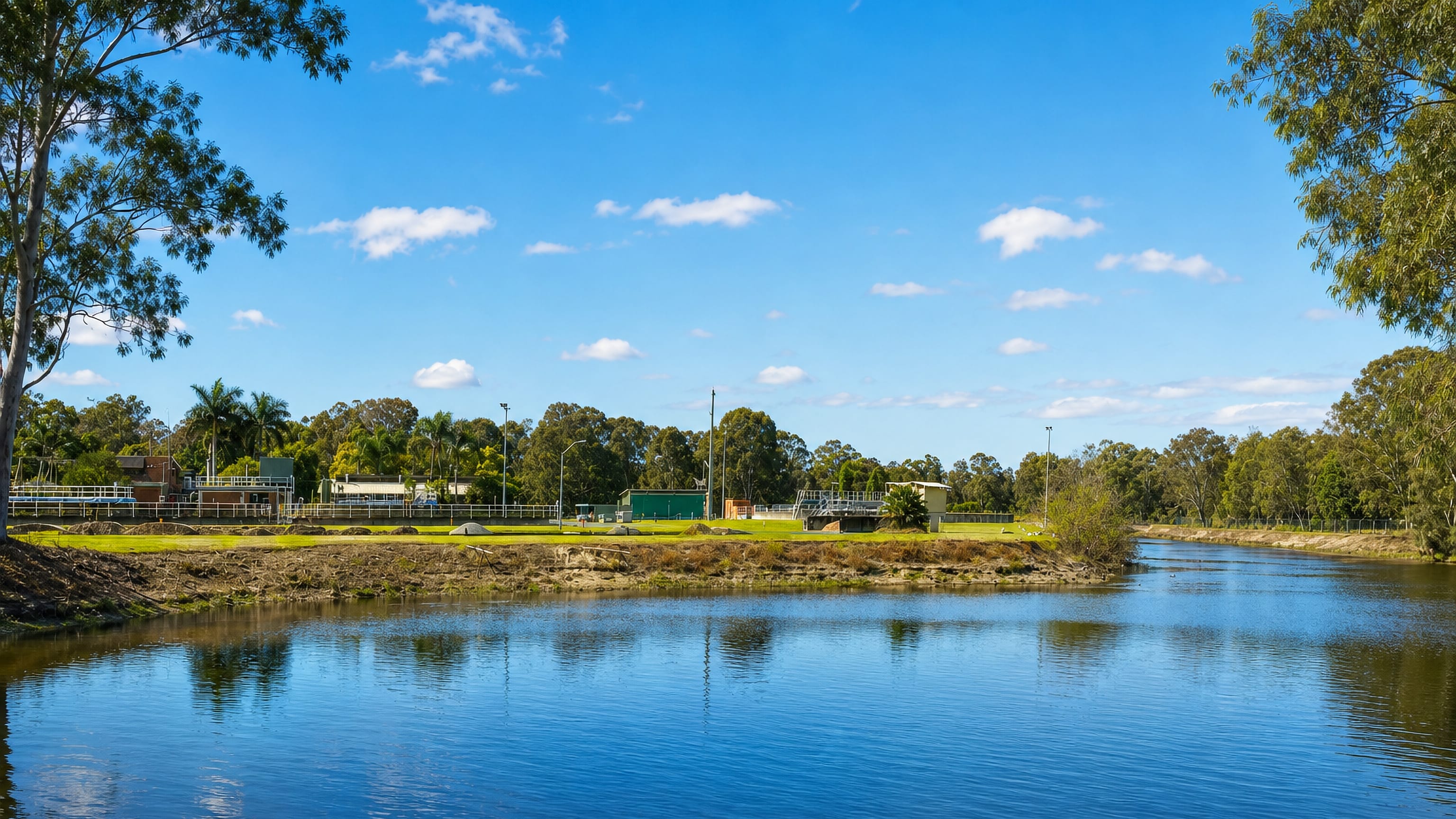 Eucalypts and sports grounds along a calm waterway in Elanora on the Gold Coast.