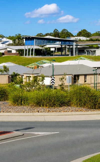 New brick-and-tile homes and a landscaped roundabout in Ormeau on Queensland's northern Gold Coast