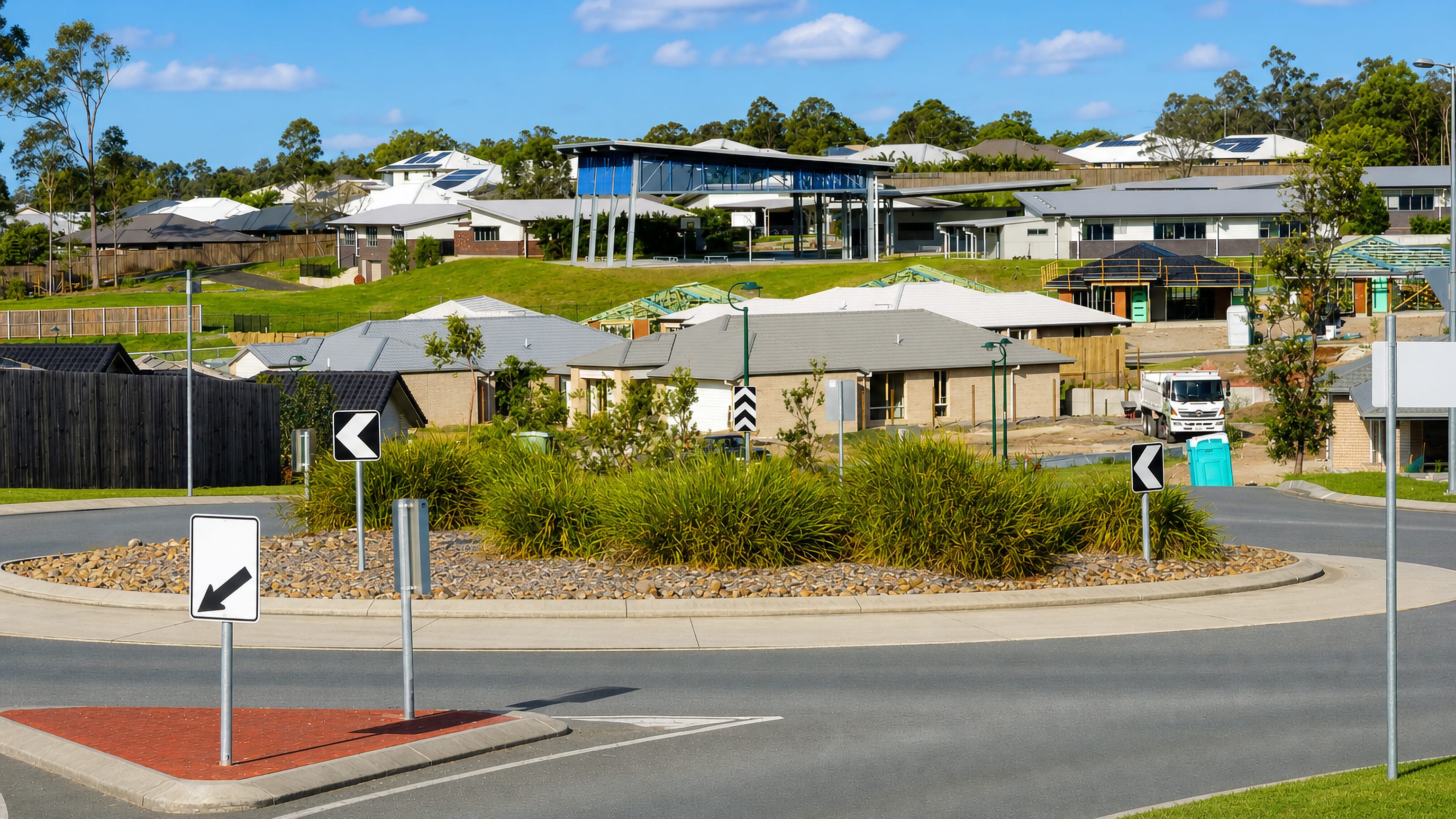 New brick-and-tile homes and a landscaped roundabout in Ormeau on Queensland's northern Gold Coast