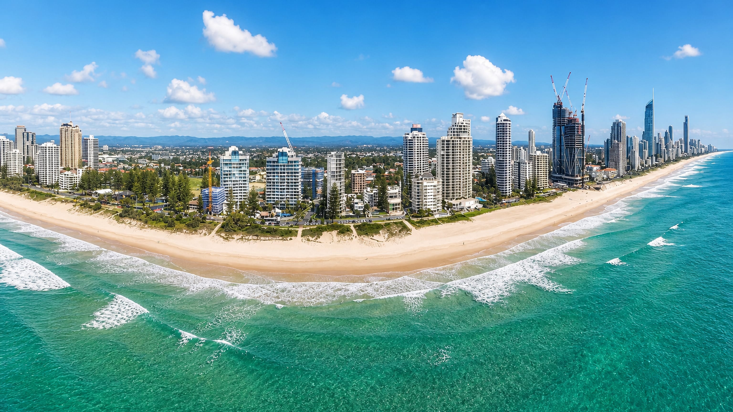 Aerial view of the Surfers Paradise high-rise skyline along the curving Gold Coast beach, Queensland