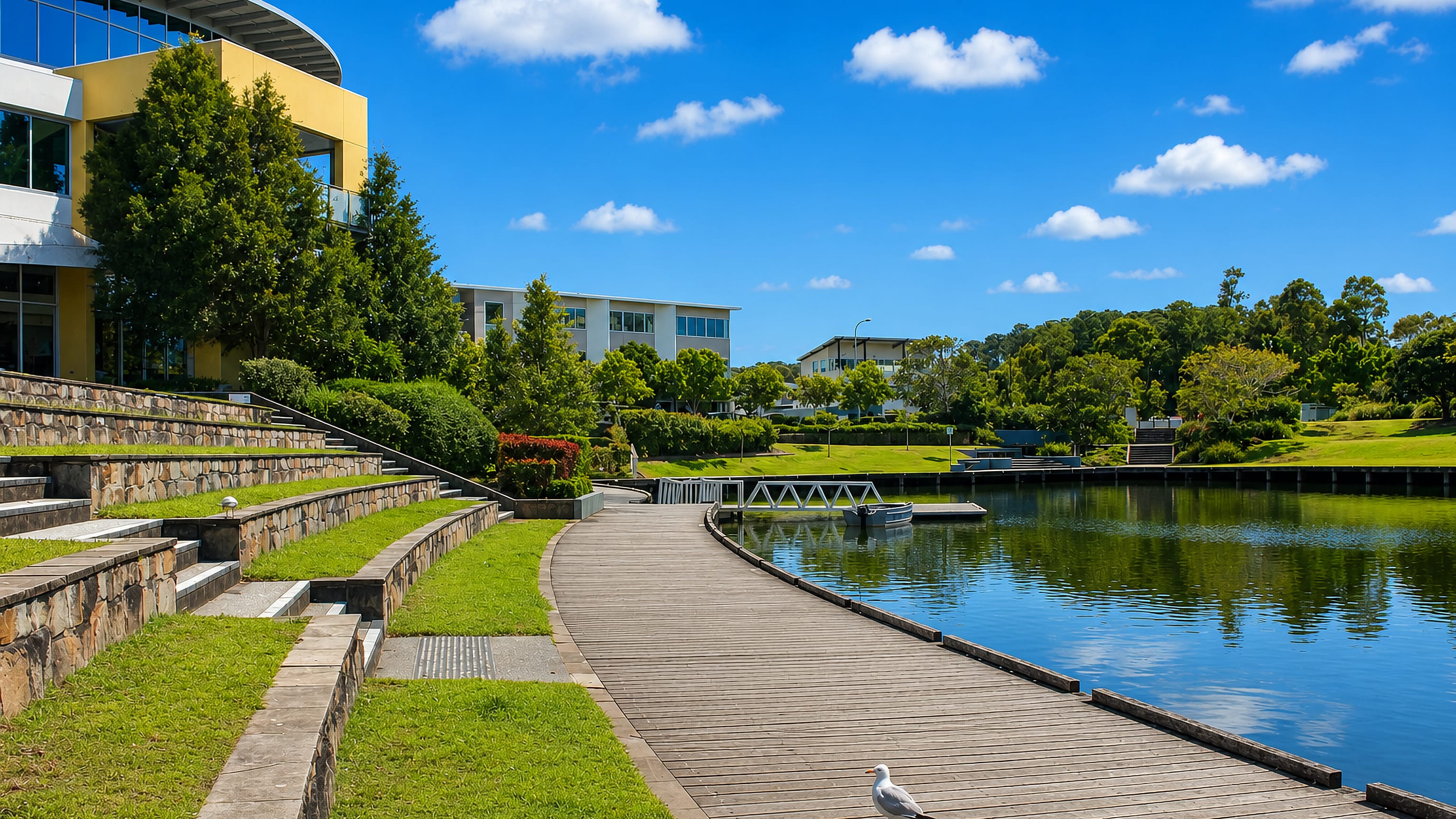 Lakeside boardwalk and modern buildings at Varsity Lakes on the Gold Coast under clear blue sky
