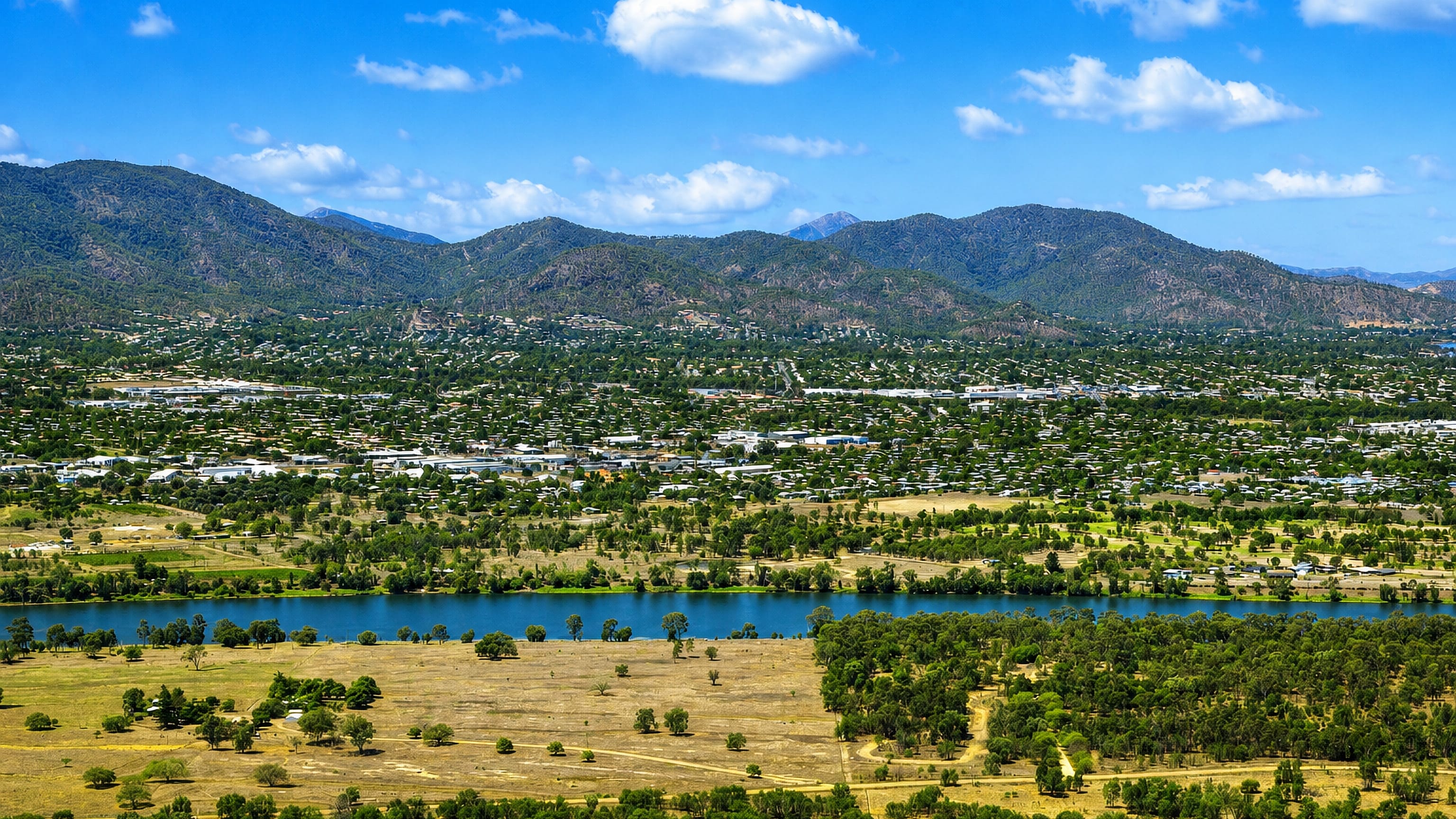 The Fitzroy River winding past Rockhampton, Queensland, with the Berserker Range rising behind the town.