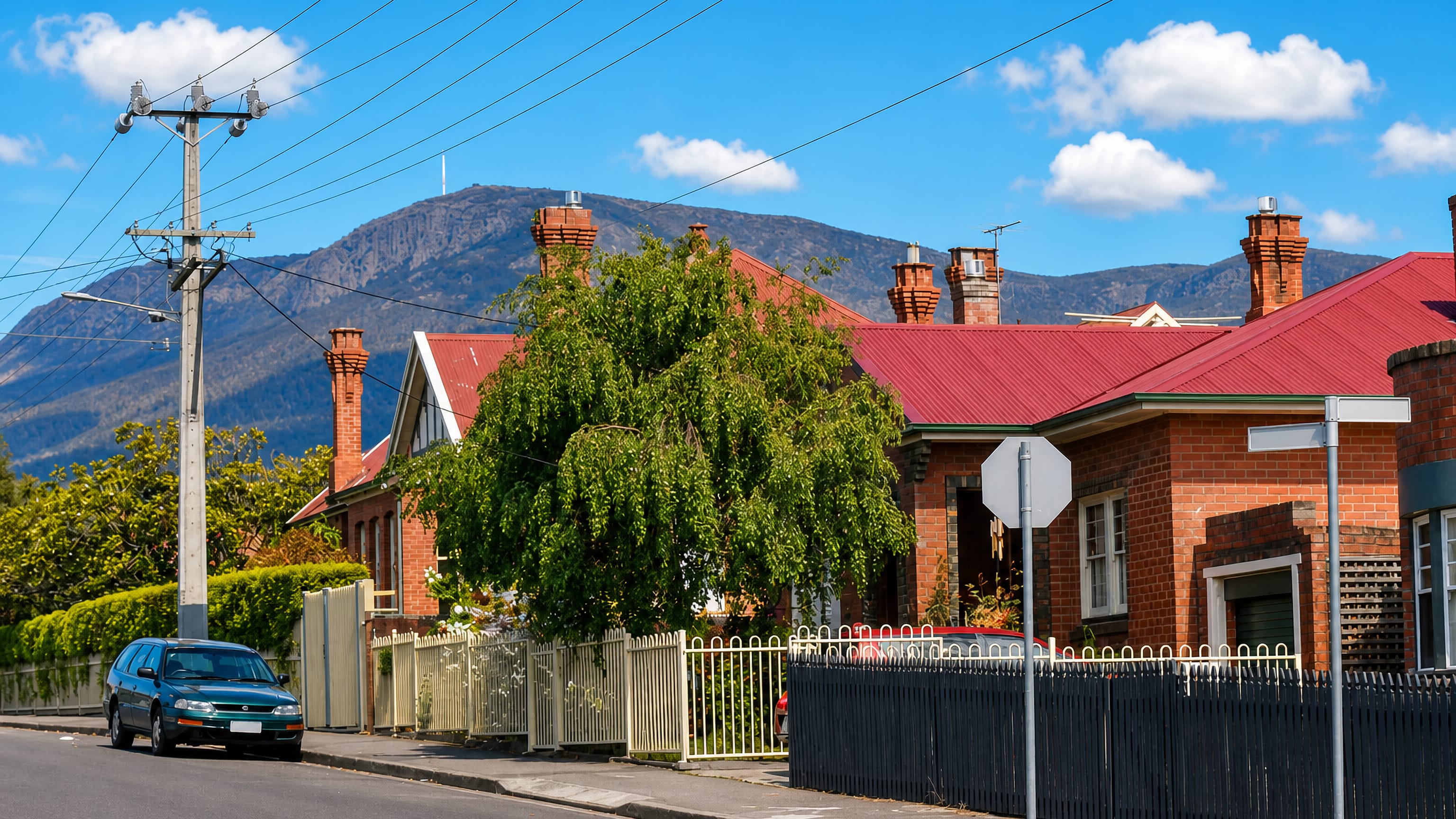 Victorian brick cottages with red roofs and picket fences in New Town, Hobart, below kunanyi/Mount Wellington.