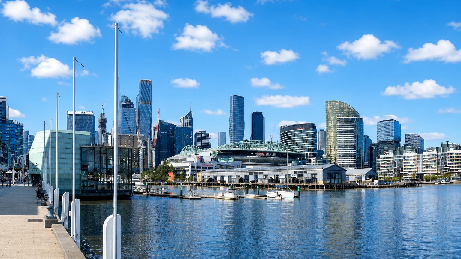 Melbourne's Docklands waterfront and CBD skyline across the harbour under a clear blue sky