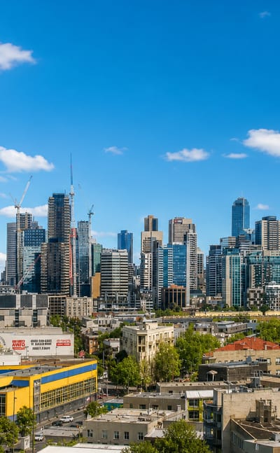 The Melbourne CBD skyline including Eureka Tower rising beyond leafy inner-suburb rooftops in Parkville
