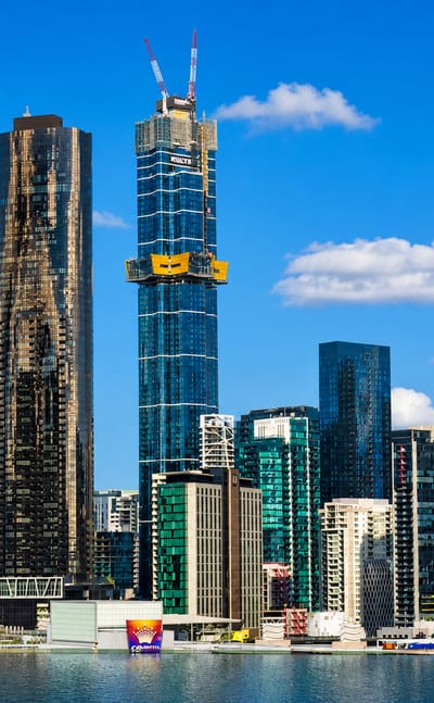 Riverside high-rise towers of Melbourne's Southbank precinct along the Yarra under a clear sky.
