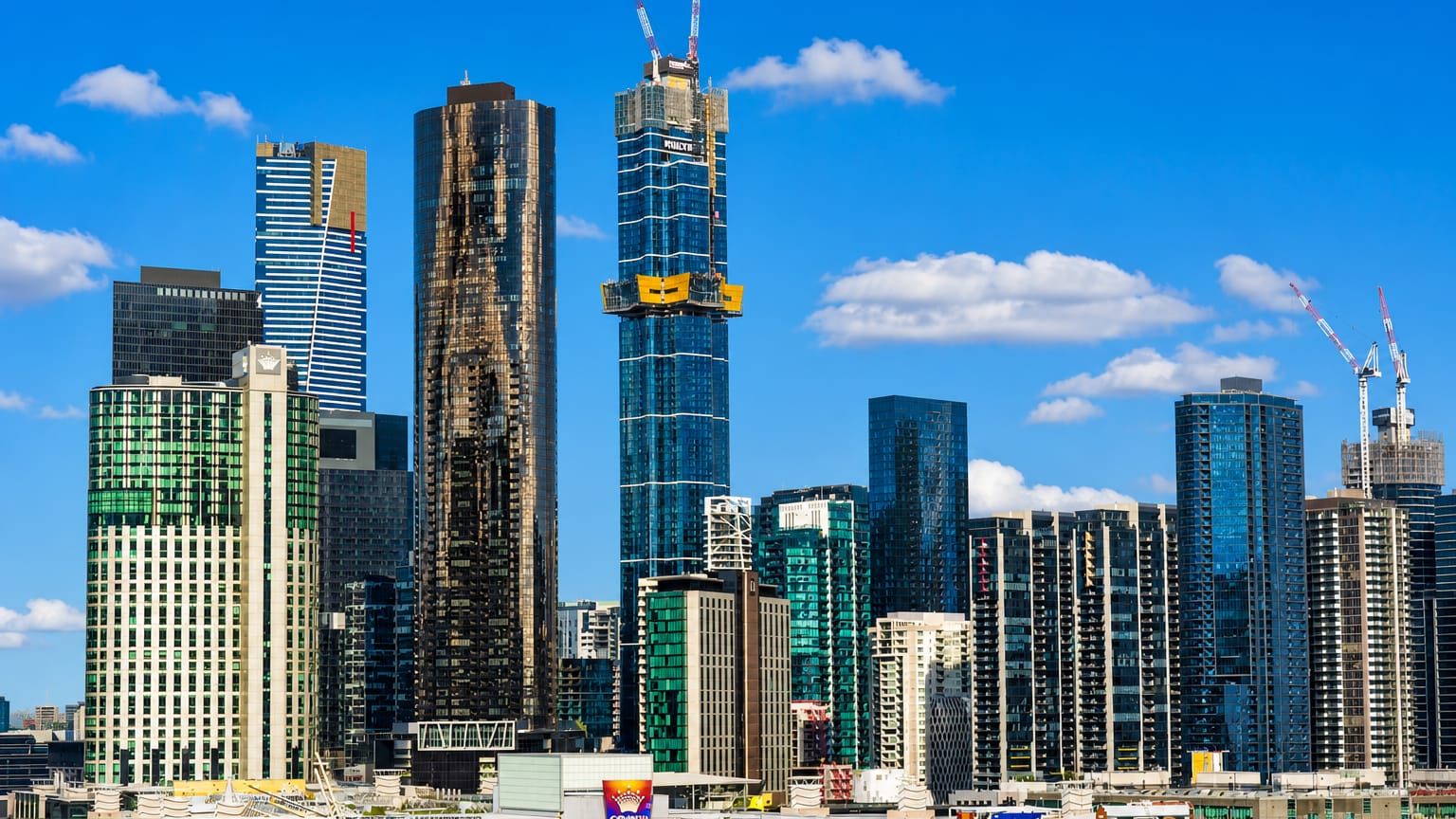 Riverside high-rise towers of Melbourne's Southbank precinct along the Yarra under a clear sky.