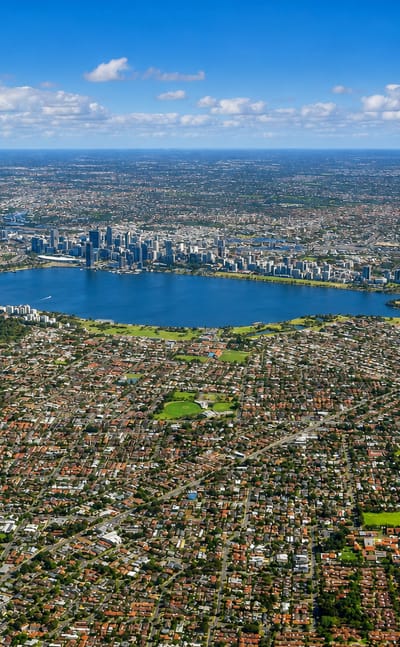Aerial view of Perth with the Swan River curving past the downtown skyline and surrounding suburbs