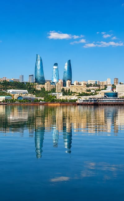 Baku waterfront skyline with the Flame Towers and Baku TV Tower reflected in the Caspian Sea, Azerbaijan.